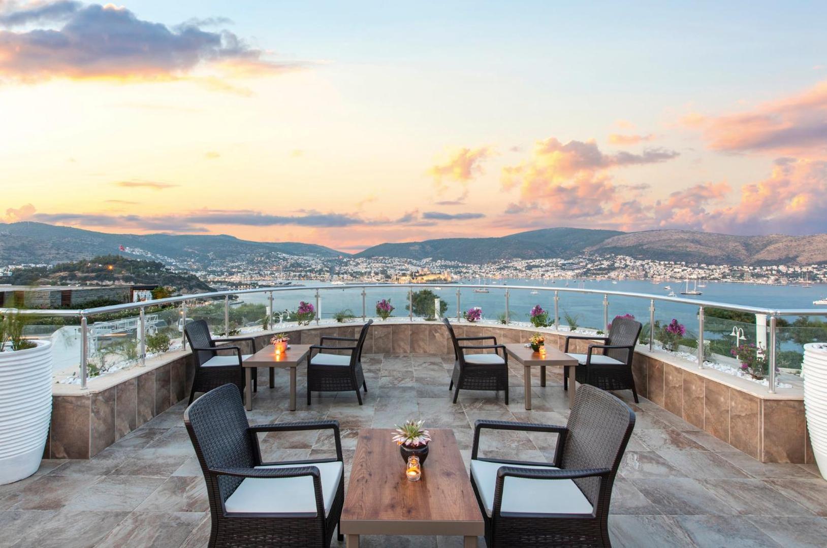 Baska Resort Bodrum atpūtas zona uz terases saulrieta laikā, skats uz Bodrumas pilsētu un piekrastes kalniem