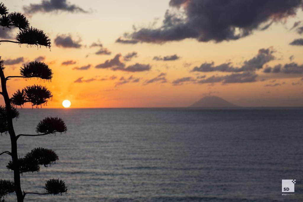 Tonicello Resort & Spa skats uz saulrietu virs Tirēnu jūras Kalabrijā — tālumā redzams Stromboli vulkāna siluets un vakara debesis