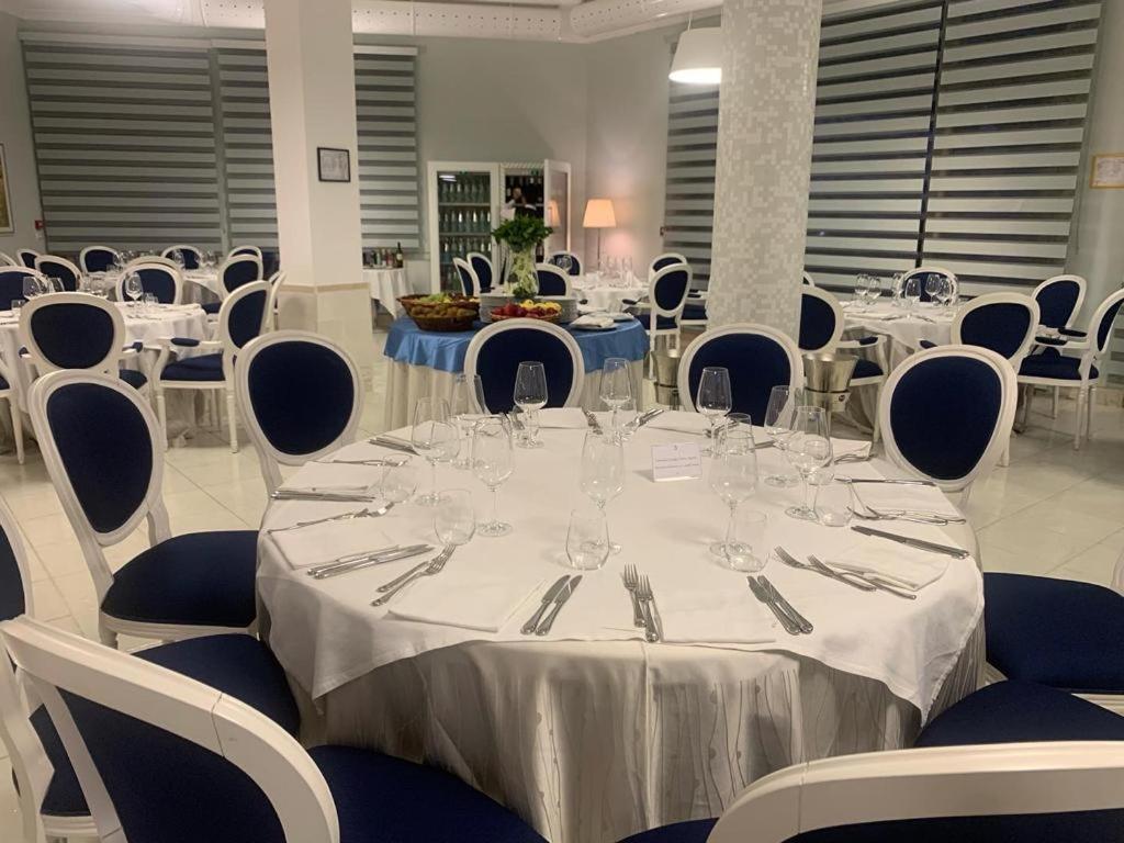 Galia Luxury Resort iekštelpu restorāns ar eleganti klātiem apaļiem galdiem, tumši ziliem krēsliem un modernu interjeru