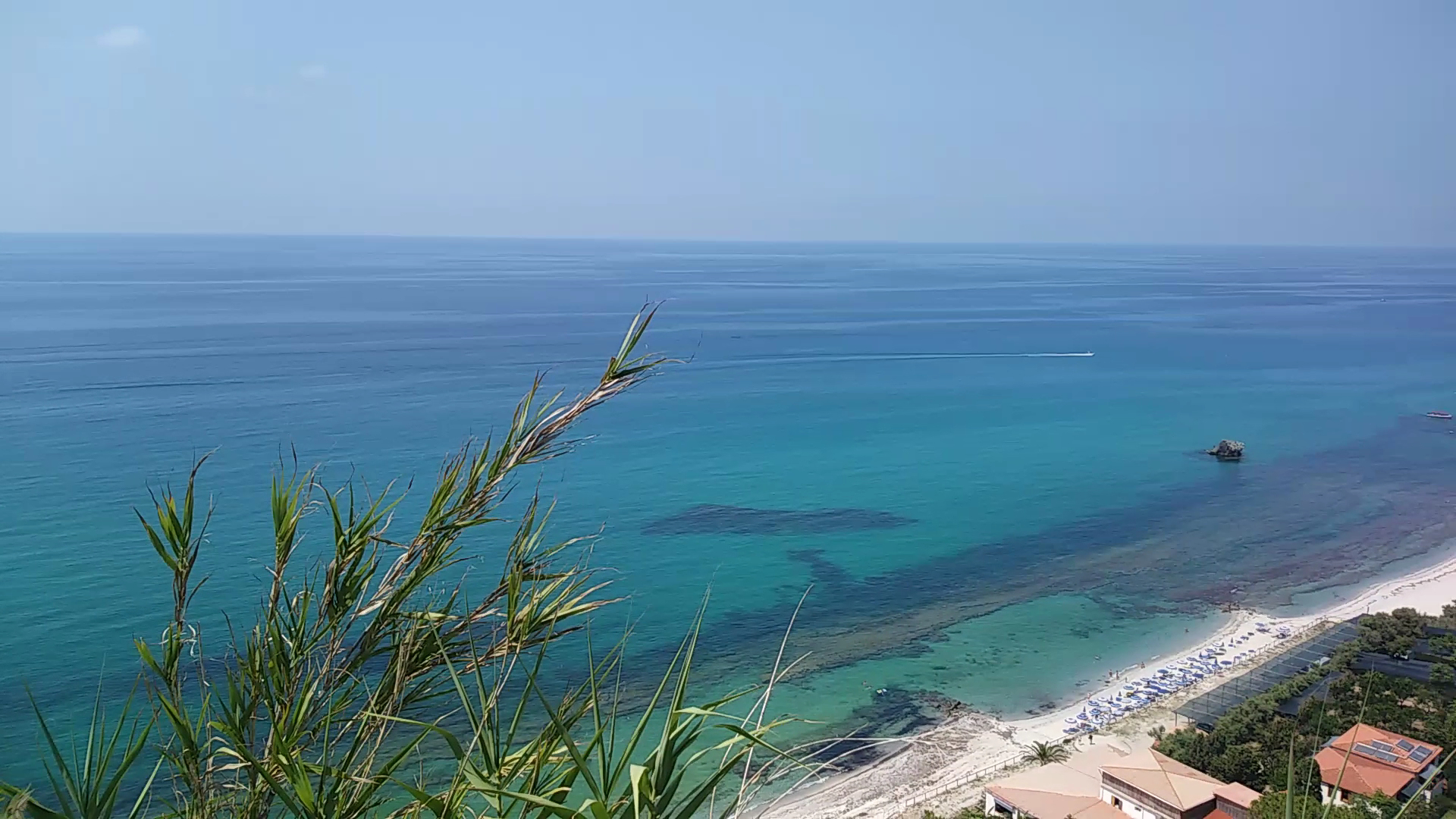 Skats no augšas uz Villagio Marco Polo privāto pludmali ar saulessargiem un dzidru tirkīza ūdeni Kalabrijas piekrastē