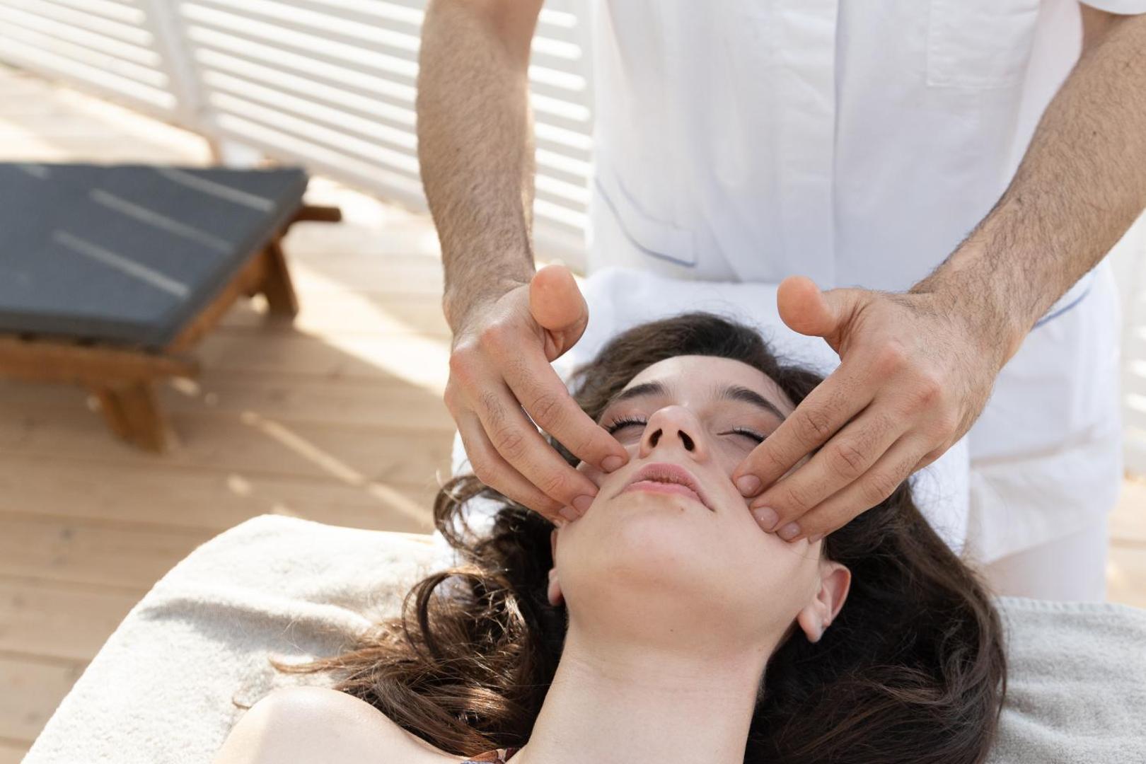 Sejas masāžas procedūra Midenza Seaside & Nature Retreat spa centrā — profesionāls personāls sniedz relaksējošu procedūru viesnīcas viesim