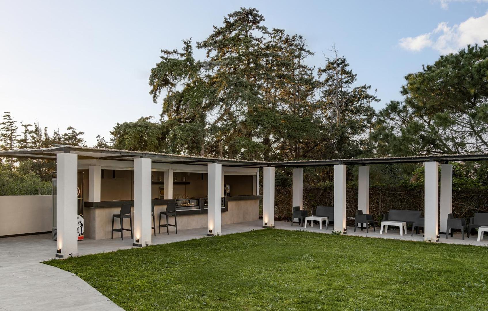 Sunrise Village Hotel āra bārs un atpūtas zona ar dārzu Krētā — moderna terase ar bāra krēsliem un galdiņiem koku pavēnī