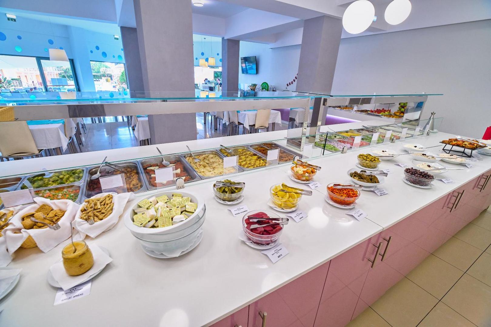 Sunrise Village Hotel bufetes galds ar plašu uzkodu, mērču un dārzeņu izvēli — daudzveidīga starptautiskā virtuve viesnīcas restorānā