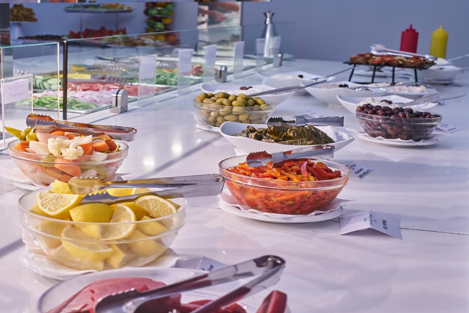 Sunrise Village Hotel uzkodu bufete ar grieķu salātiem, olīvām un mērcēm — svaigi dārzeņi un tradicionālās uzkodas
