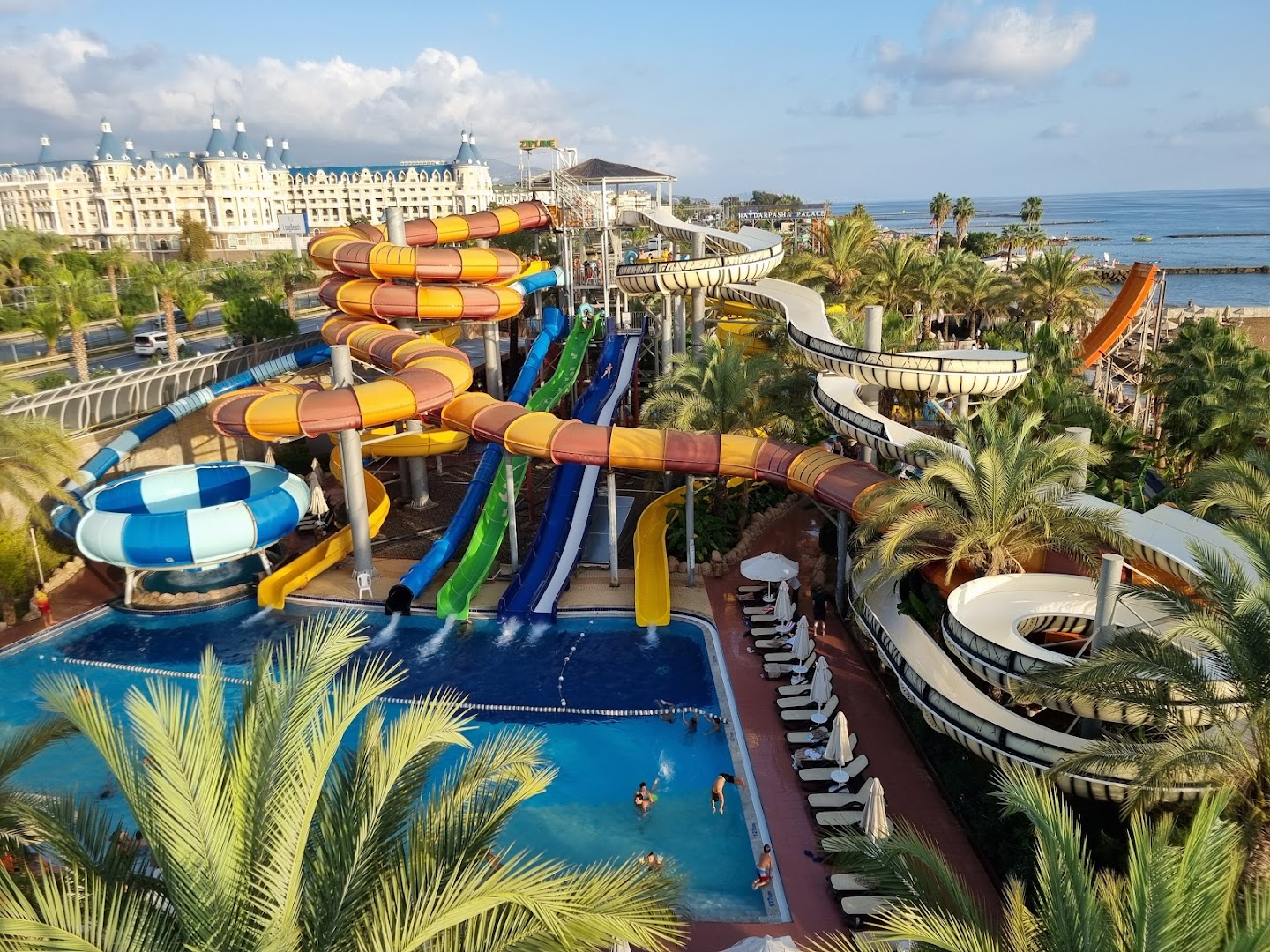 Long Beach Resort akvaparks ar krāsainiem slidkalniņiem un skatu uz viesnīcas ēku un Vidusjūru Alanjā
