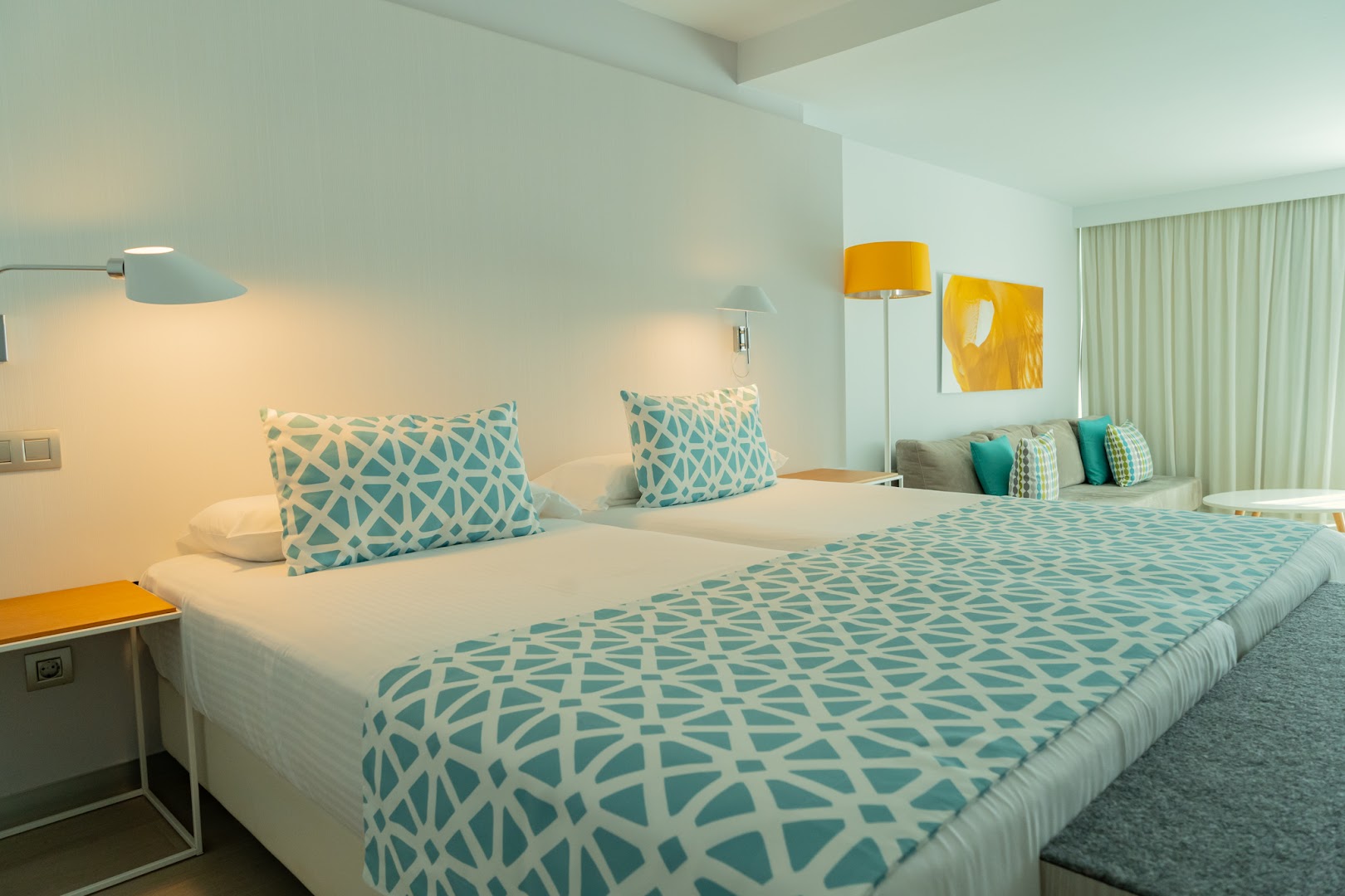 Santa Mónica Suites Hotel moderns divvietīgs numurs ar gaišu interjeru, dīvānu un skatu uz logu Grankanārijas kūrortā