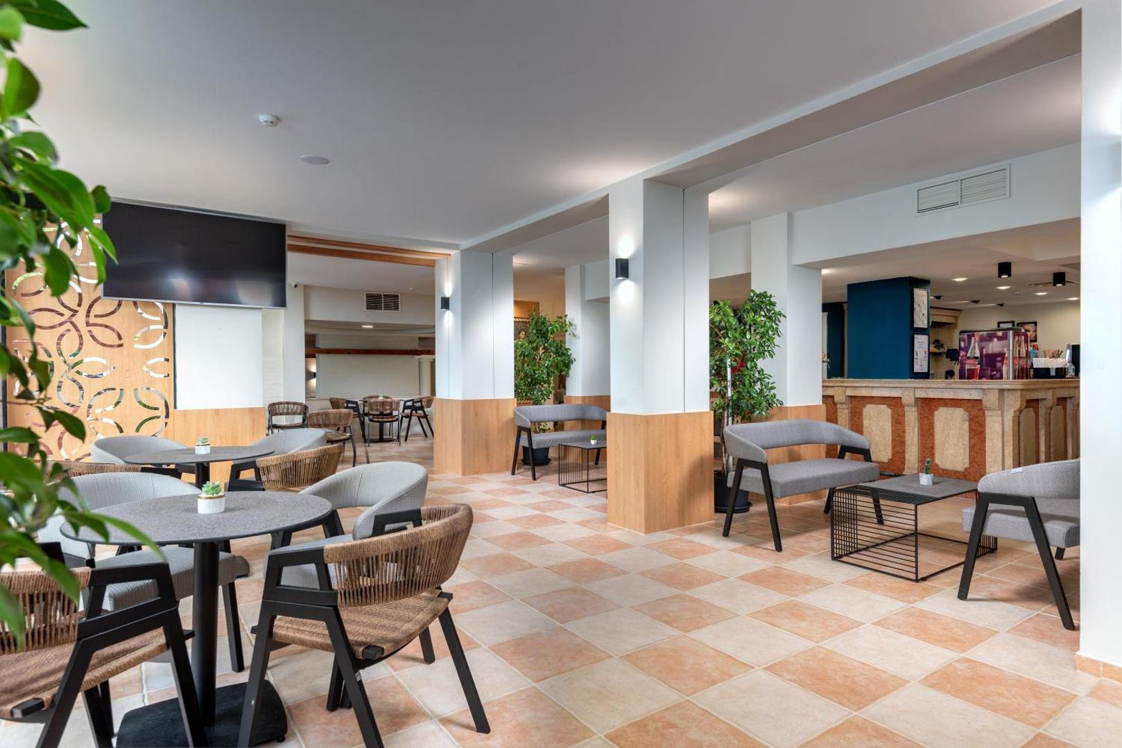 Sentido Bellevue Beach bāra zona ar modernām mēbelēm, koka apdari un plašu telpu viesu uzņemšanai Saulainā krasta kūrortā