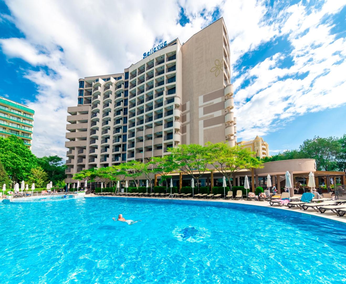Sentido Bellevue Beach viesnīcas ēka un lielais āra baseins ar sauļošanās krēsliem Saulainajā Krastā, Bulgārijā
