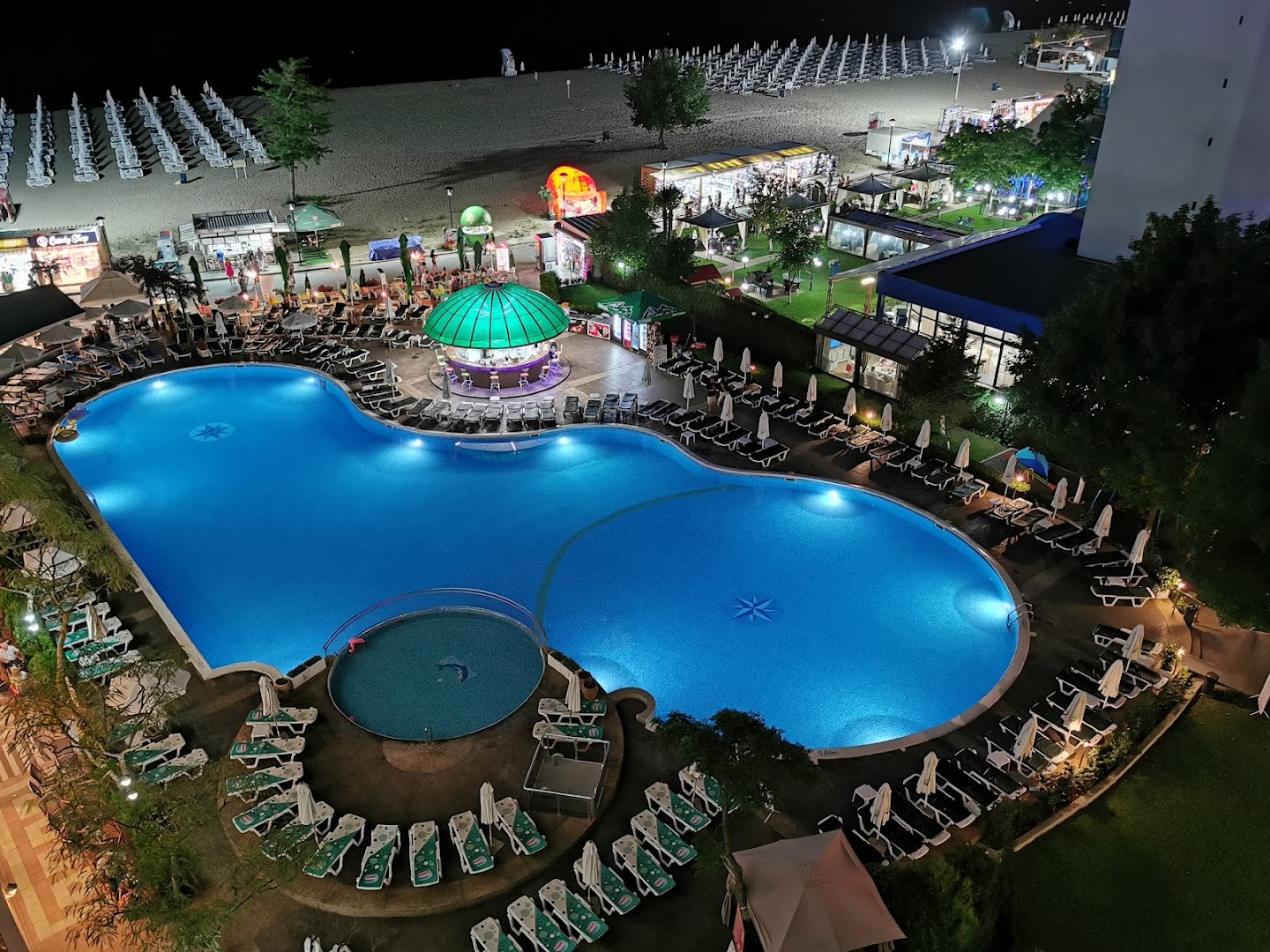 Sentido Bellevue Beach izgaismots āra baseins naktī un skats uz pludmali Saulainajā Krastā, Bulgārijā