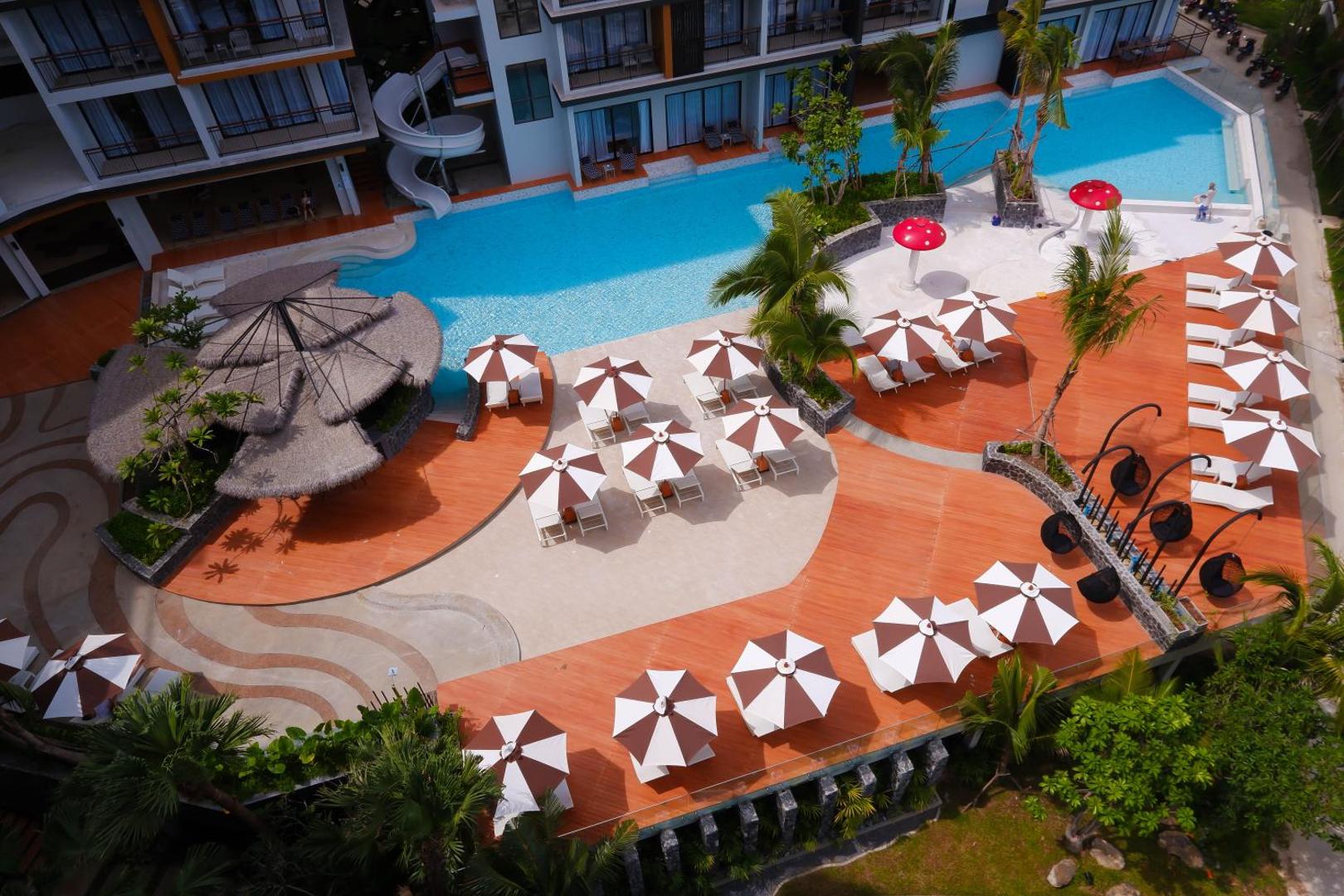 Sea Seeker Krabi Resort plašais āra baseins no putna lidojuma — atpūtas zona ar saulessargiem, palmām un ūdens slidkalniņu Ao Nangā