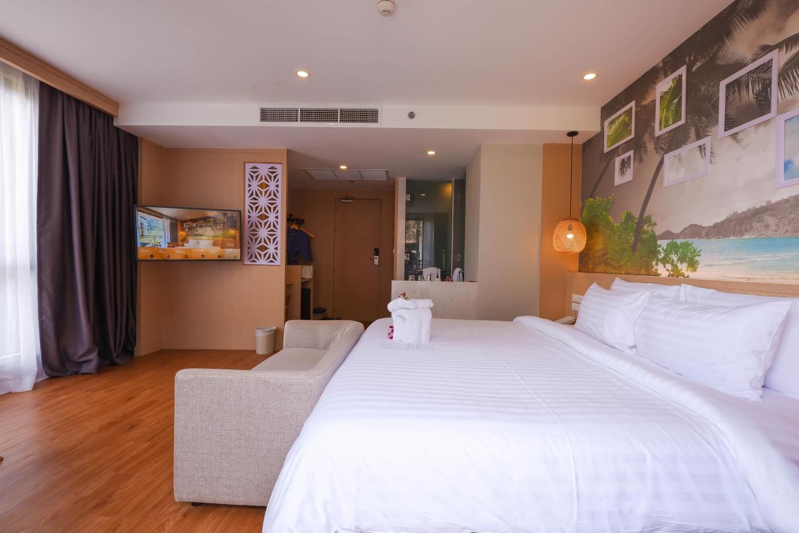 Sea Seeker Krabi Resort moderns divvietīgs numurs ar lielu gultu, sienas dekorācijām un atvērtā tipa vannas istabas zonu