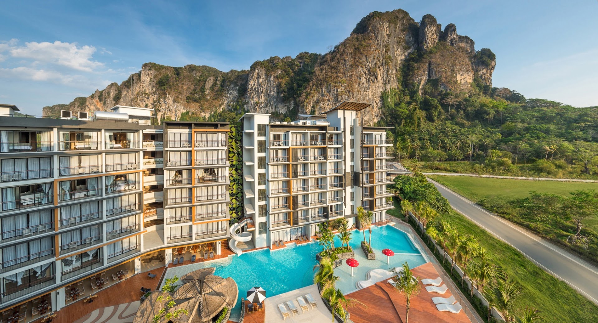 Panorāmas skats uz Sea Seeker Krabi Resort kompleksu, baseinu un apkārtējo kalnu ainavu saulrietā