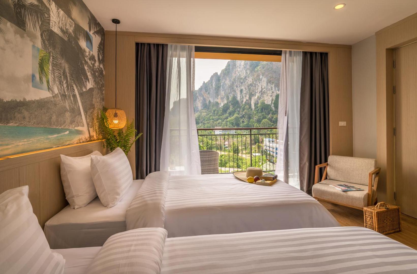 Sea Seeker Krabi Resort gaišs numurs ar divām gultām un balkonu, no kura paveras skats uz iespaidīgām klintīm Krabi reģionā