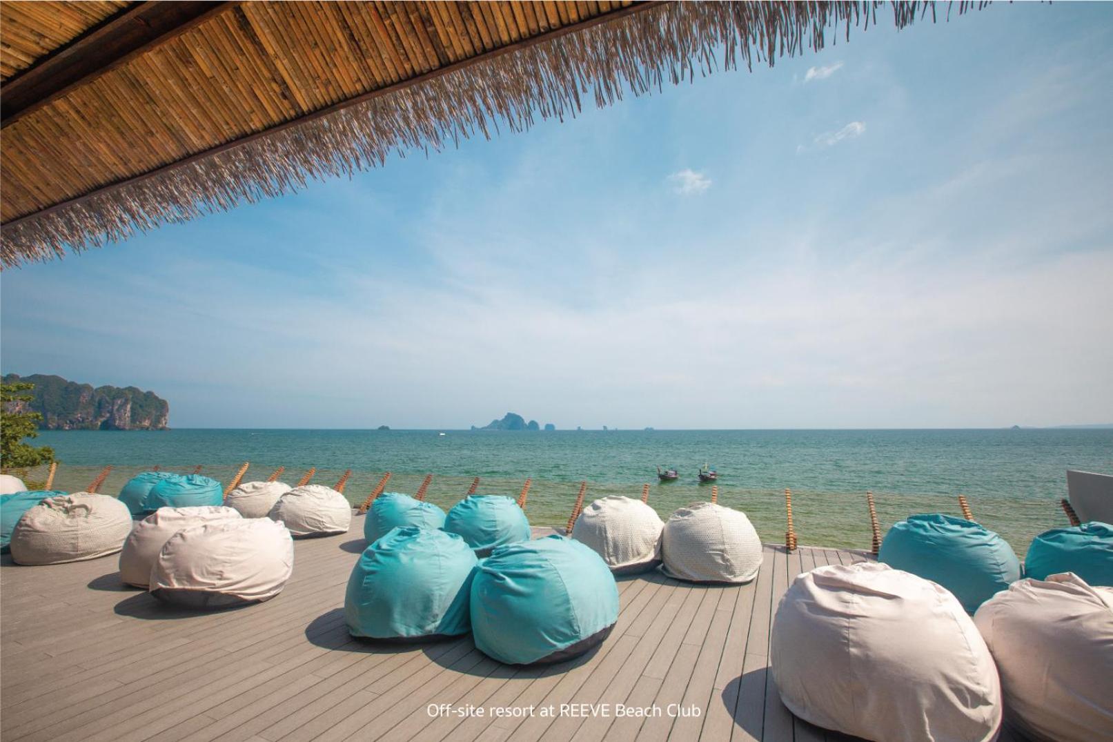 Sea Seeker Krabi Resort atpūtas zona ar mīkstajiem sēžammaisiem uz koka terases pie jūras Krabi reģionā, Taizemē