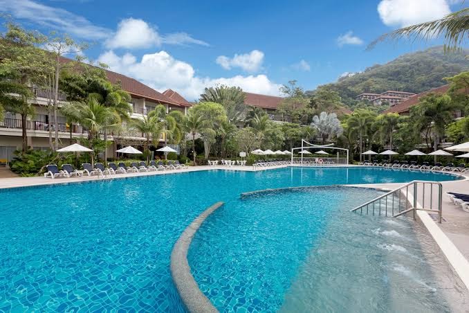 Centara Karon Resort Phuket baseins ar hidromasāžas zonu un skatu uz kalniem un viesnīcas ēkām Puketā
