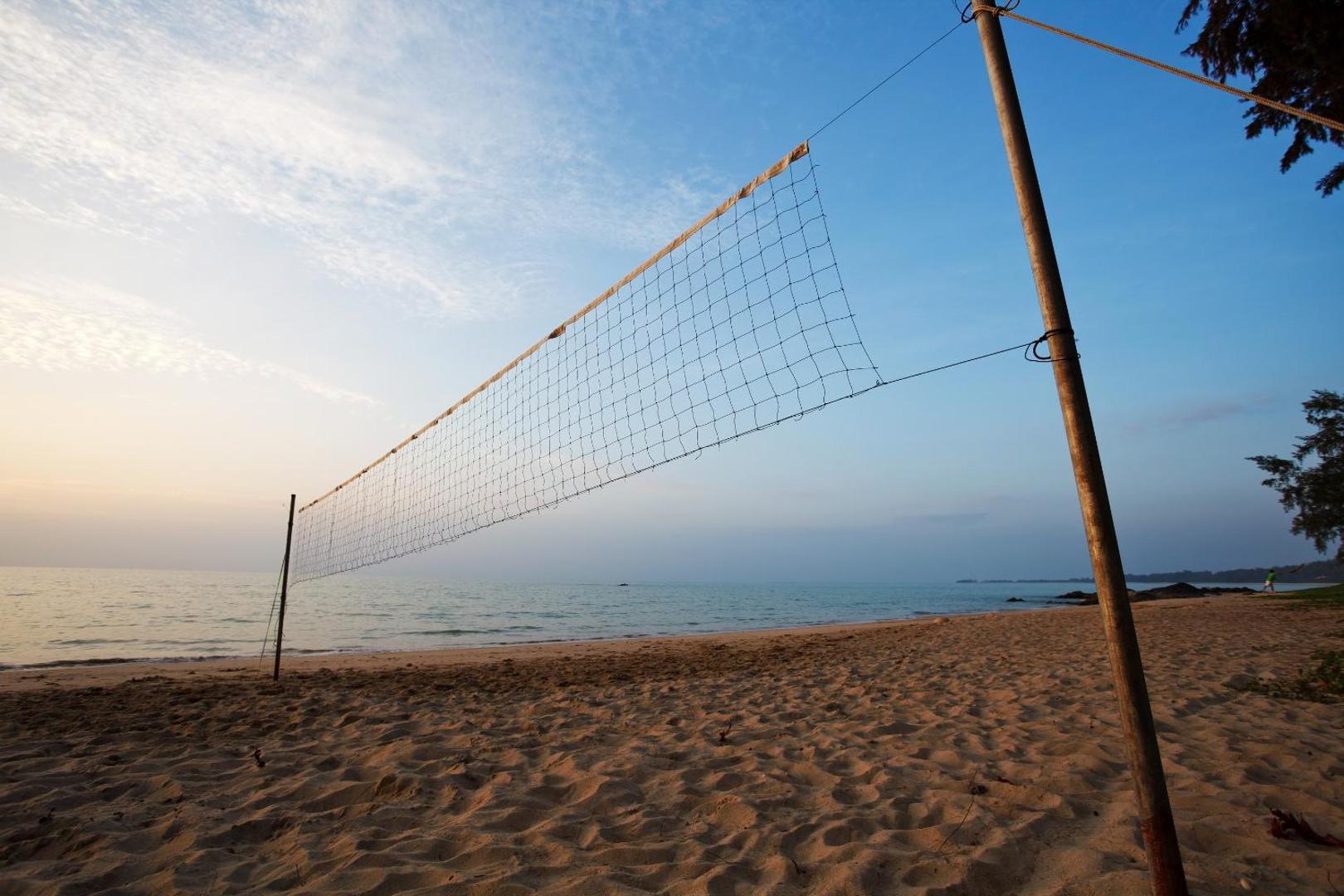 Volejbola tīkls Mai Khao Lak Beach Resort & Spa smilšu pludmalē saulrieta laikā ar skatu uz Andamanu jūru