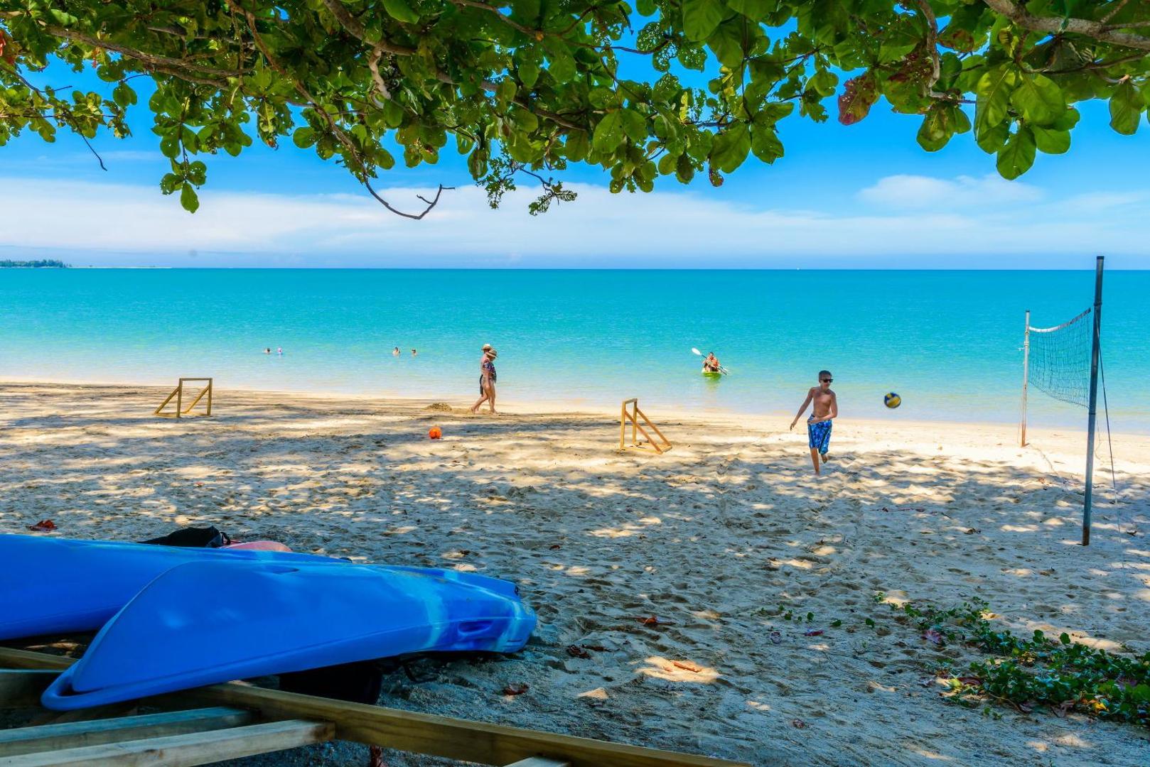 Mai Khao Lak Beach Resort & Spa privātā pludmale ar zeltītām smiltīm, tirkīza ūdeni, volejbola tīklu un kajakiem