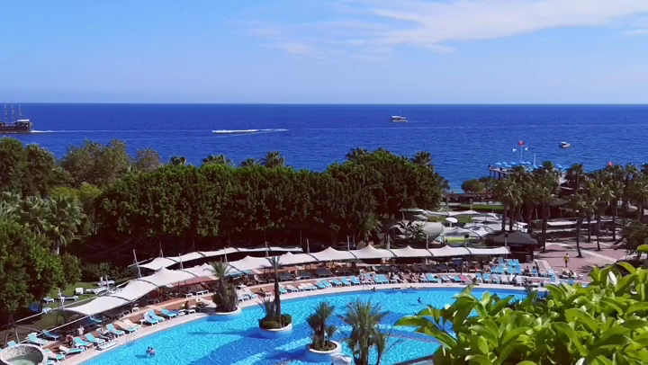 Limak Limra Hotel & Resort skats no augšas uz plašo āra baseinu kompleksu un Vidusjūras piekrasti Kemerā, Turcijā.