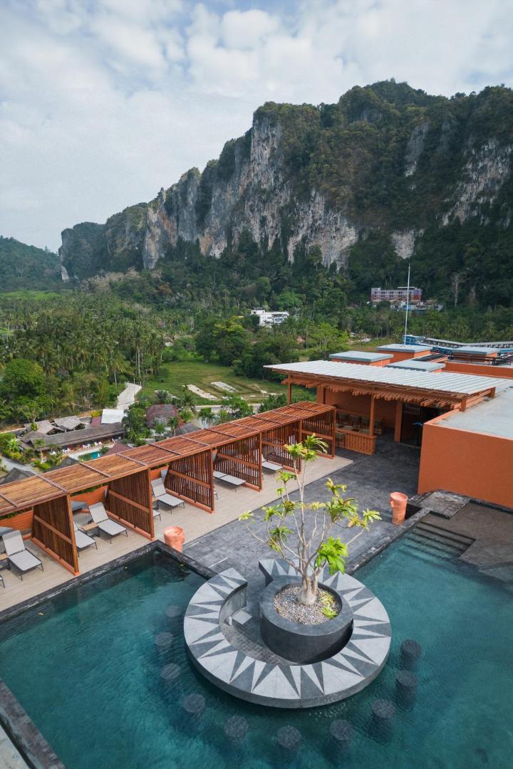 Hotel Adam Krabi jumta terase ar baseinu, sauļošanās zonu un skatu uz iespaidīgām klintīm Ao Nang reģionā, Taizemē