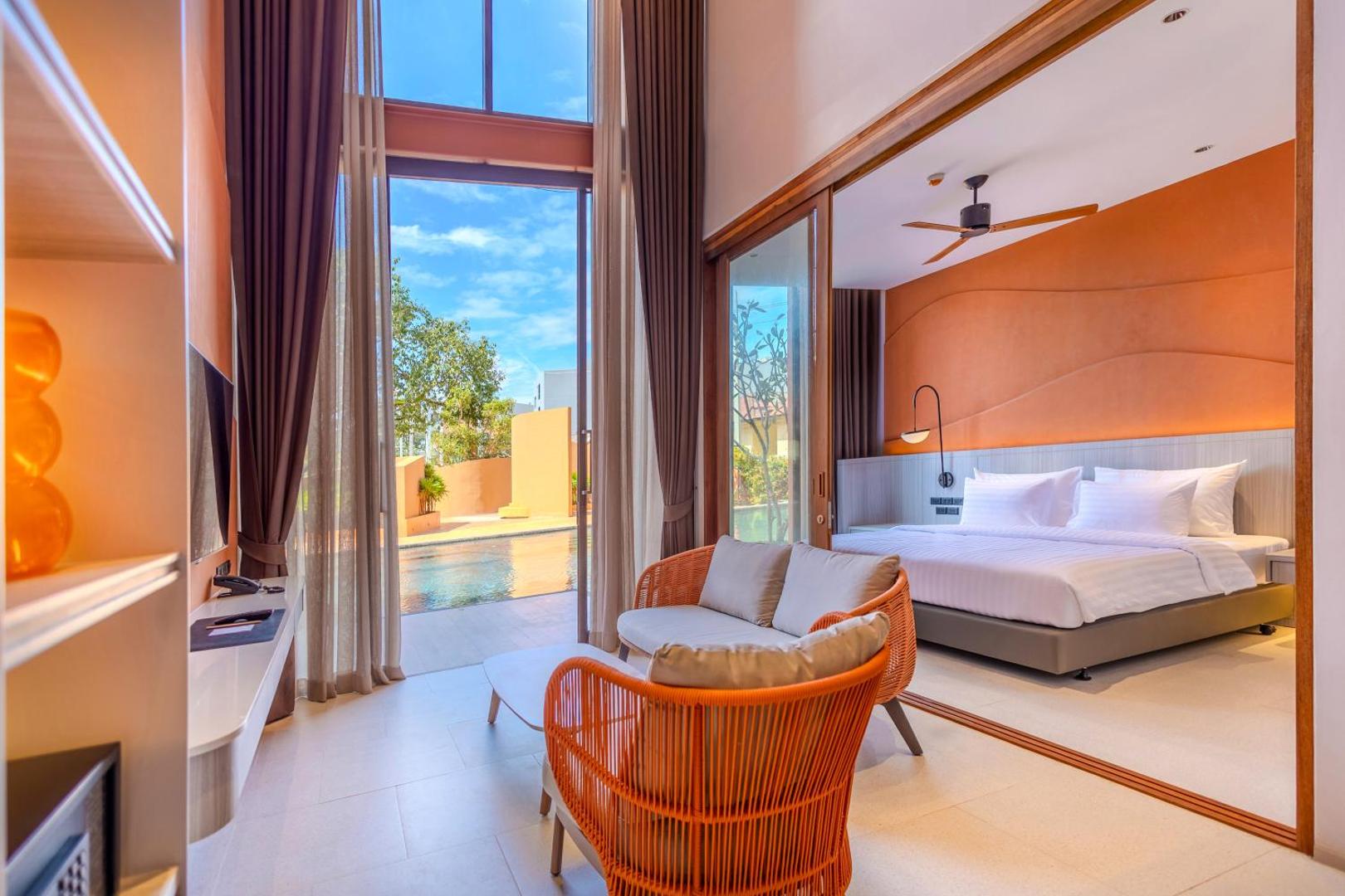 Hotel Adam Krabi numurs ar tiešu piekļuvi baseinam, atpūtas zonu un skatu uz pagalmu caur lieliem stikla logiem