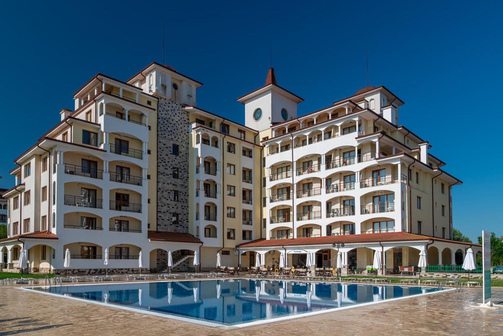 Sunrise All Suites Resort viesnīcas fasāde un galvenais baseins vakarā — arhitektūra ar balkoniem un numuriem Obzorā
