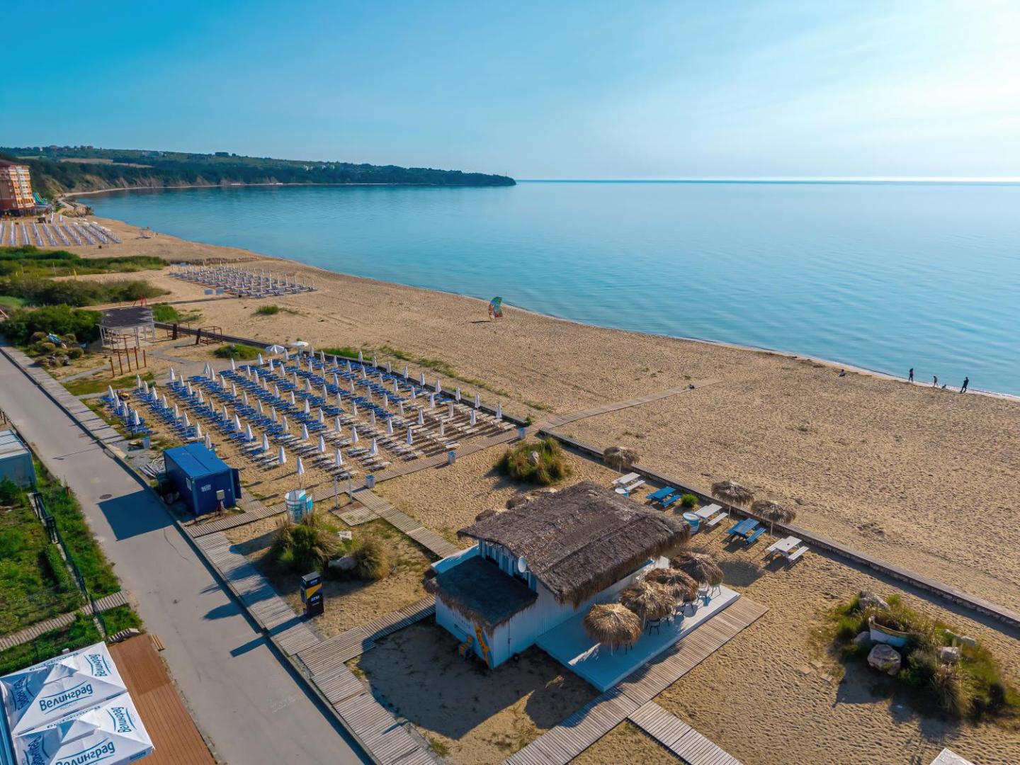 Aerofoto skats uz Sunrise All Suites Resort pludmali, saulessargu rindām un piekrastes bāru Obzorā, Bulgārijā