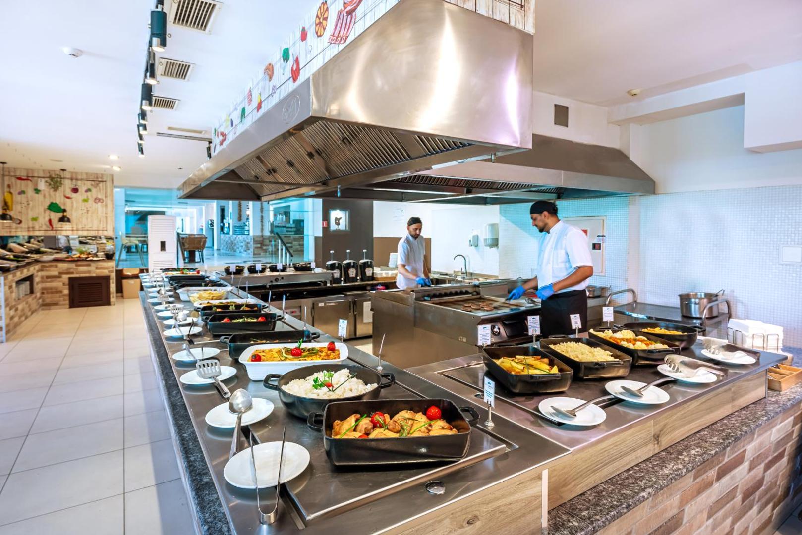 Sunrise All Suites Resort restorāna bufetes zona ar plašu silto ēdienu izvēli un pavāriem, kas gatavo viesu acu priekšā