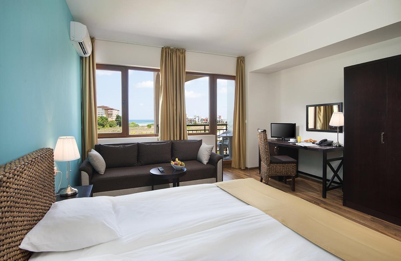 Sunrise All Suites Resort numurs ar divguļamo gultu, dīvānu un darba zonu Obzorā — gaišs interjers ar skatu uz jūru