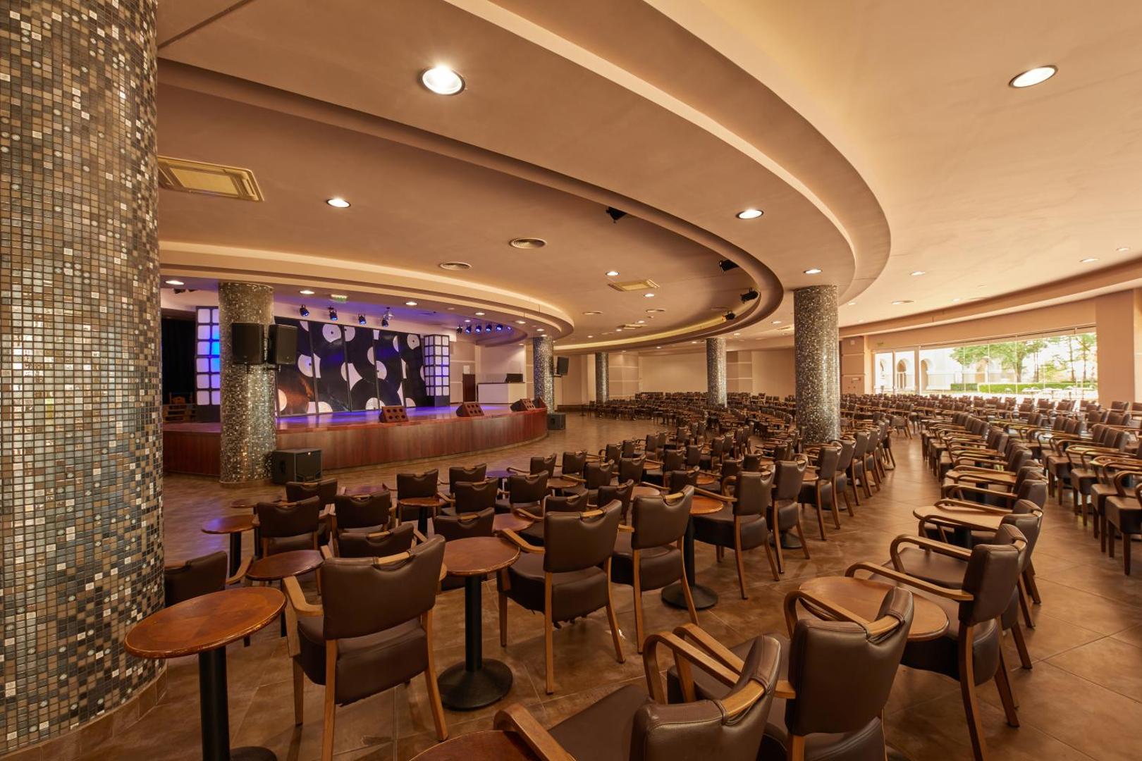 Alua Sunny Beach Resort & Spa lielā konferenču un pasākumu zāle ar daudzām sēdvietām, skatuvi un modernu apgaismojumu Saulainajā krastā.