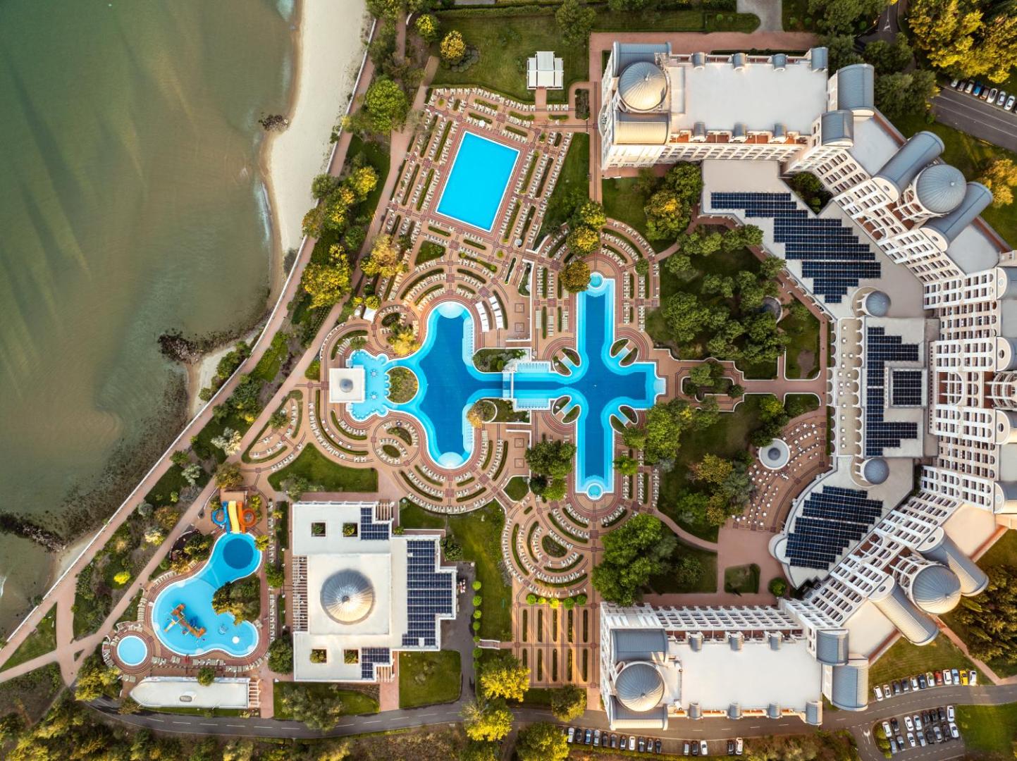 Alua Sunny Beach Resort & Spa viesnīcas kompleksa skats no putna lidojuma, parādot baseinu izvietojumu, dārzus un tiešu piekļuvi pludmalei