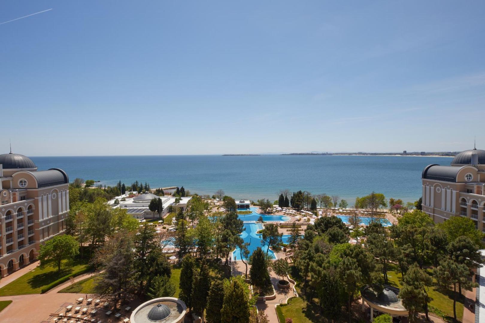 Alua Sunny Beach Resort & Spa panorāmas skats uz baseinu kompleksu un Melno jūru Saulainajā krastā, Bulgārijā, no augšas.