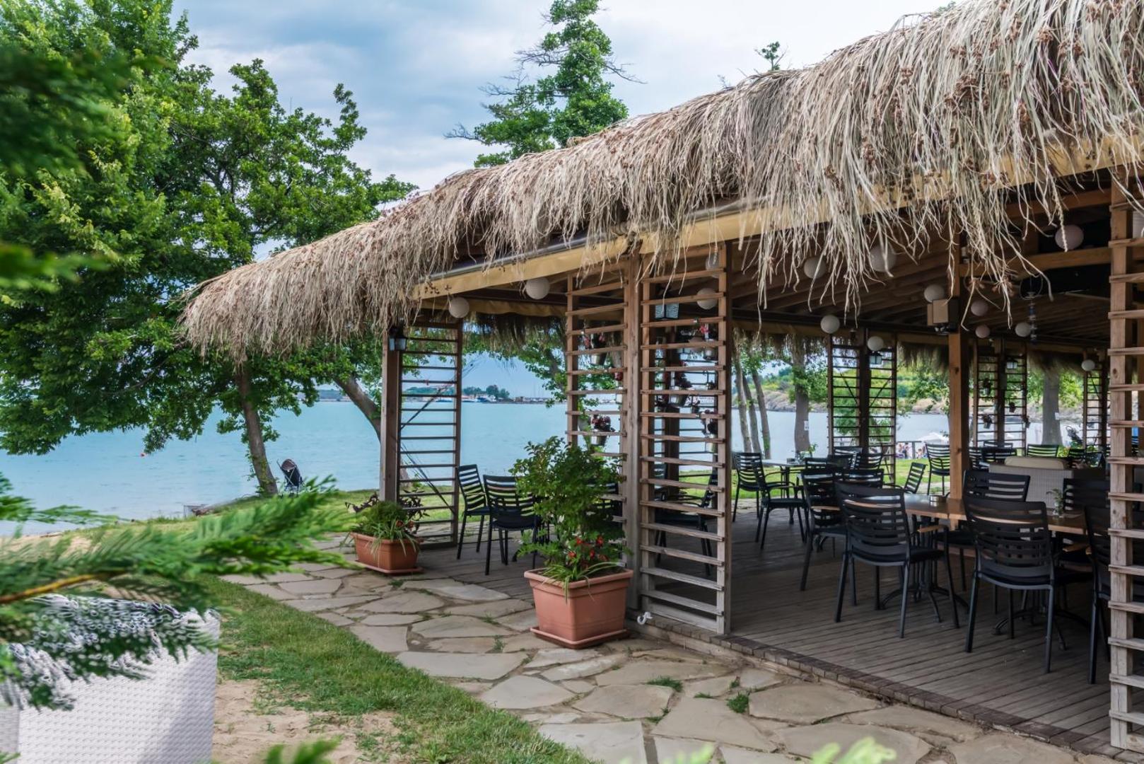 Viva Mare Beach Hotel pludmales bārs ar niedru jumtu un koka apdari — galdiņi un krēsli ar skatu uz jūru Sozopolē