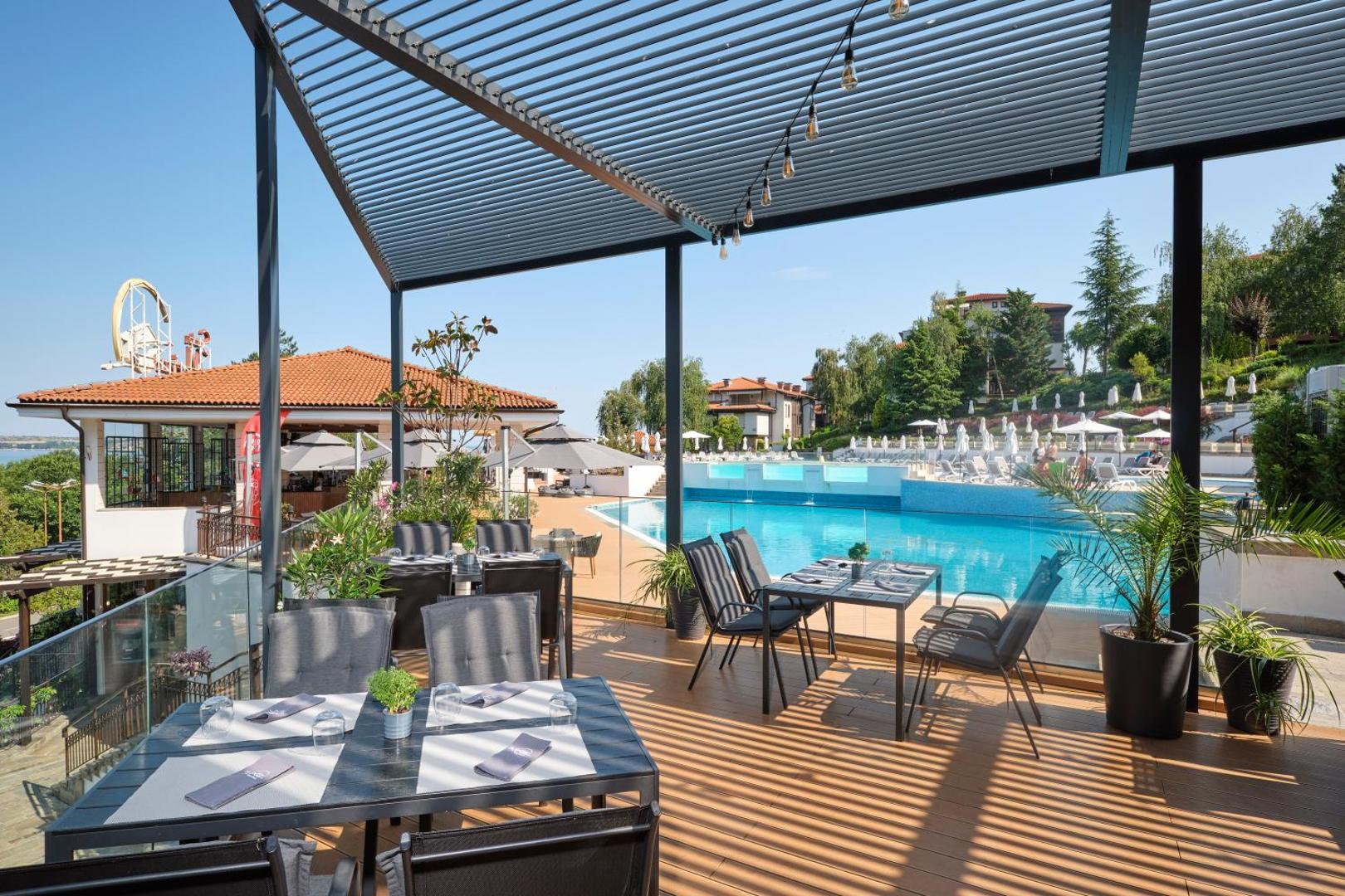 Viva Mare Beach Hotel āra terases restorāns ar skatu uz baseinu un viesnīcas teritoriju Sozopolē — moderni galdi un saules aizsegs