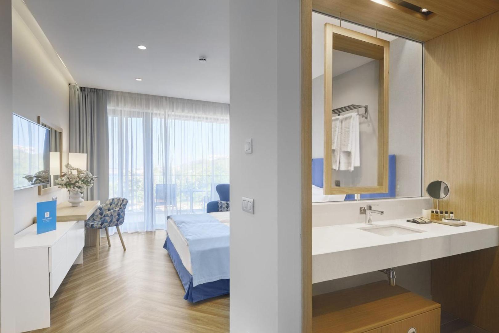 Viva Mare Beach Hotel moderns numurs ar gaišu interjeru, balkonu un atvērtā tipa vannasistabas zonu Sozopolē, Bulgārijā