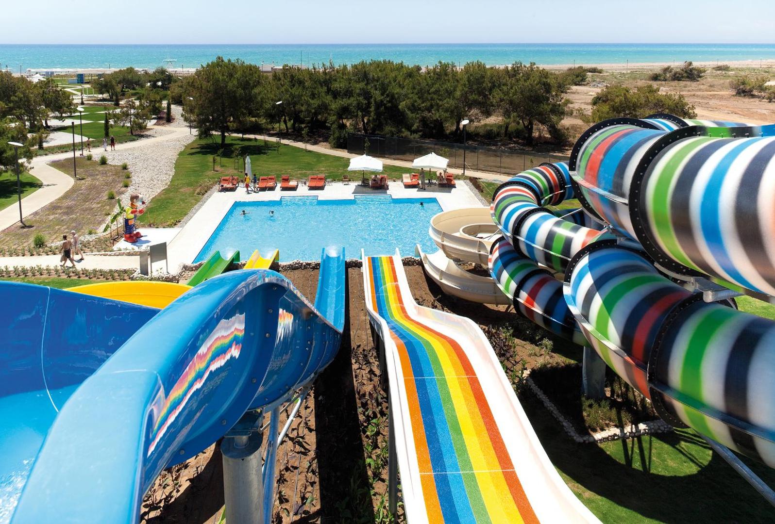 Lykia World Antalya akvaparks ar krāsainiem ūdens slidkalniņiem, bērnu baseinu un skatu uz Vidusjūras piekrasti Antalijā