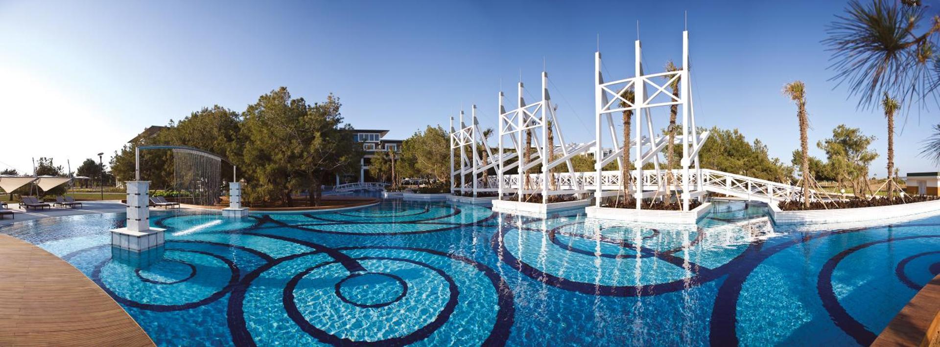 Lykia World Antalya plašais āra baseins ar unikālu dizainu, tiltiņiem un dekoratīvām konstrukcijām kūrorta teritorijā pie jūras