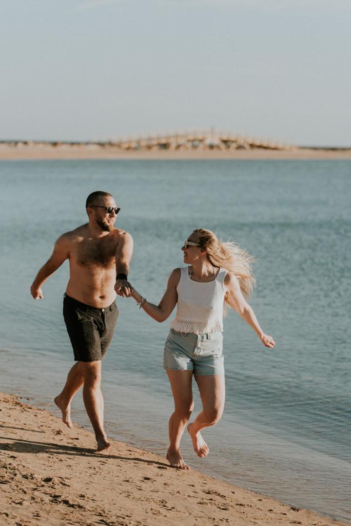Pāris skrien pa Sheraton Soma Bay Resort privāto smilšu pludmali pie dzidrā Sarkanās jūras ūdens Somabejas līcī