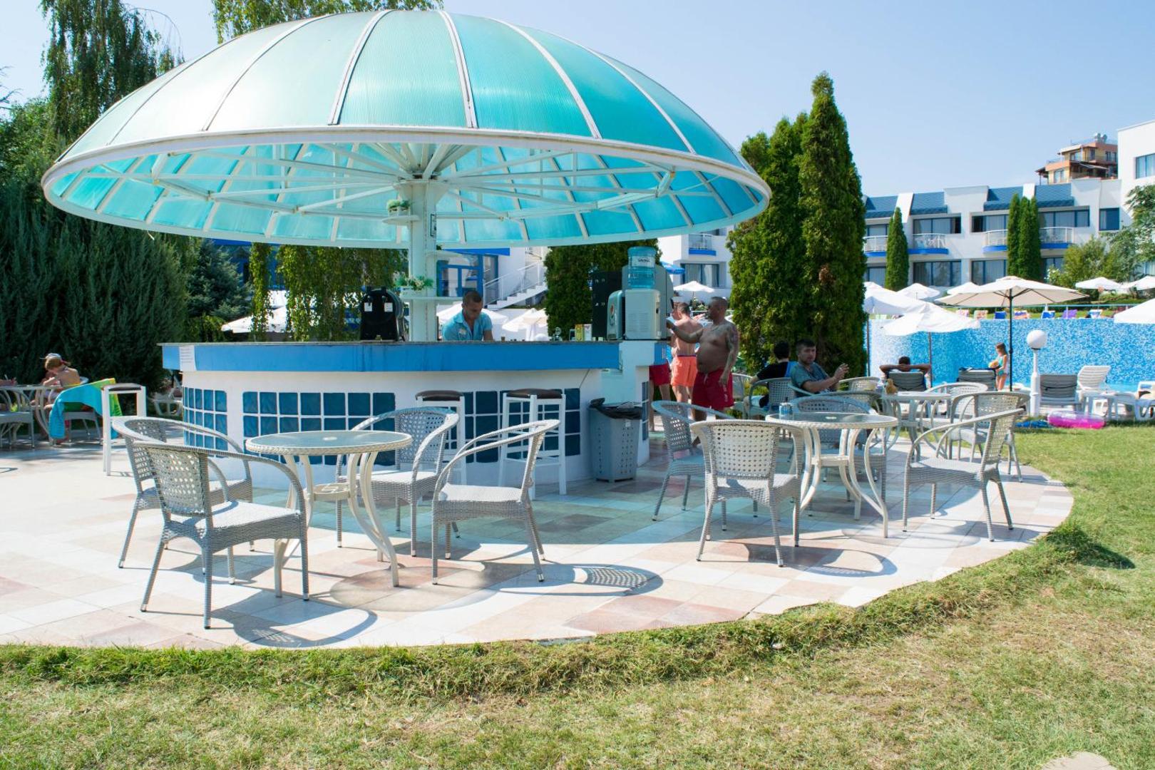 Sineva Park viesnīcas āra bārs ar zilu kupolu un sēdvietām dārzā — atpūtas zona pie baseina Saulainajā krastā, Bulgārijā.
