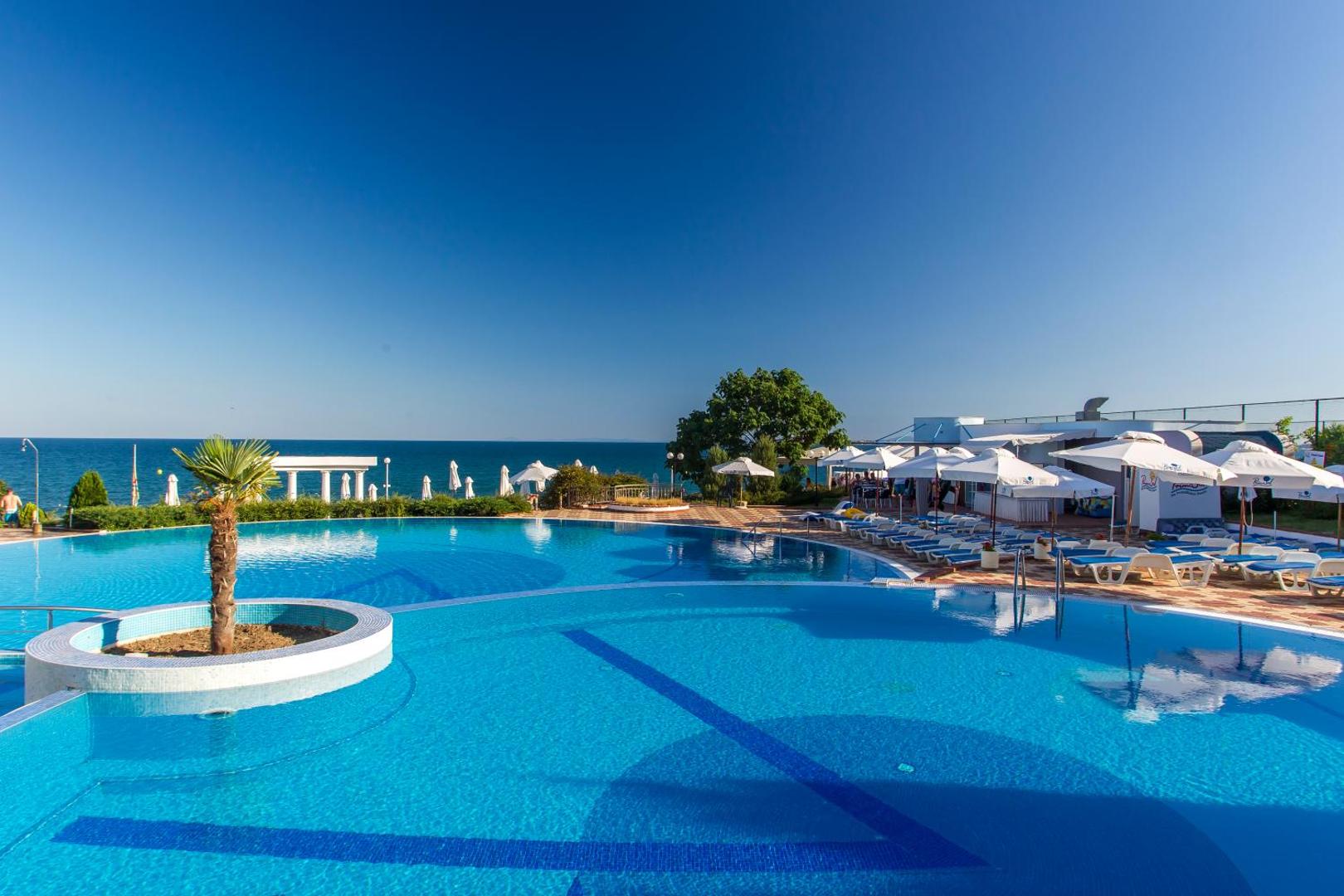 Sineva Beach āra baseins ar skatu uz Melno jūru, sauļošanās krēsliem un saulessargiem Sveti Vlas piekrastē