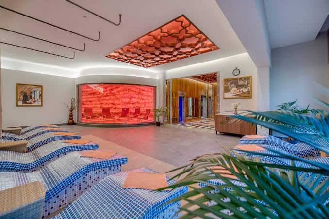 Megasaray Club Belek spa centra relaksācijas telpa ar apsildāmiem flīžu zviļņiem un sāls istabu fonā veselības procedūrām