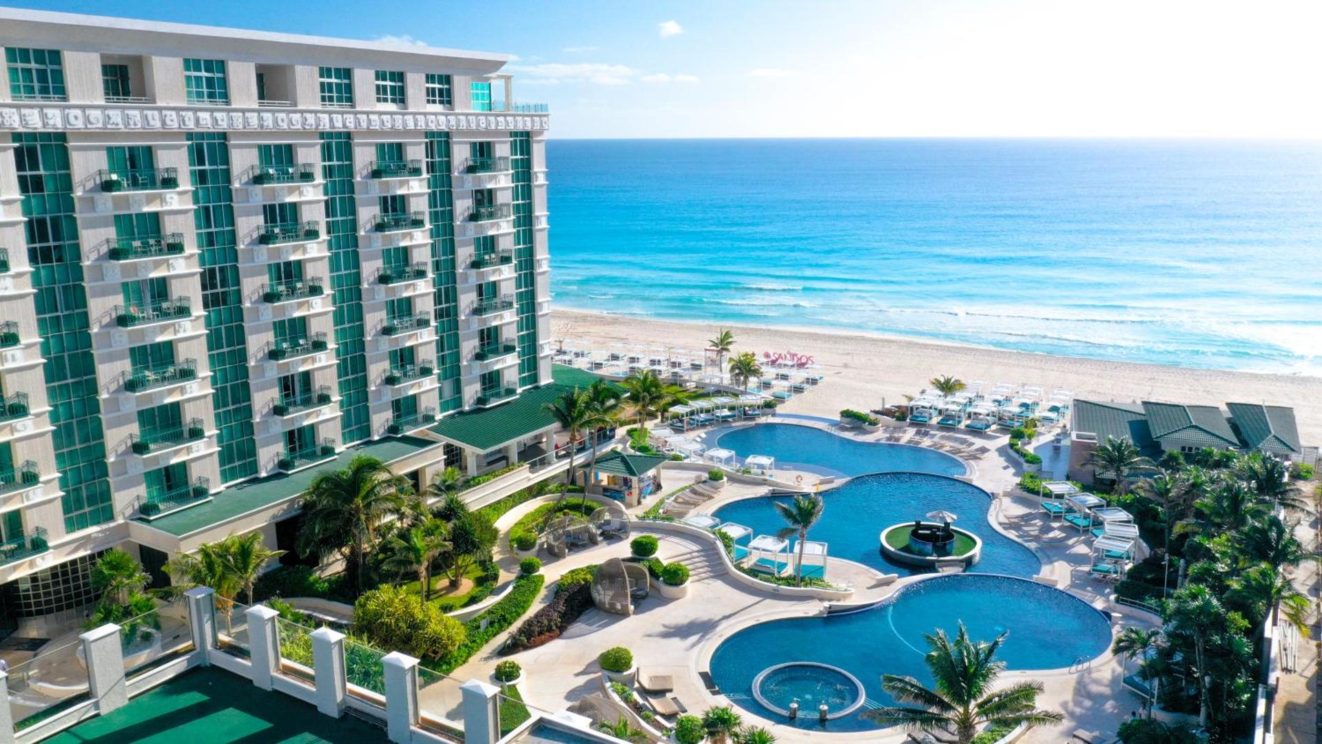 Sandos Cancun viesnīcas skats no augšas uz baseinu kompleksu un balto smilšu pludmali Karību jūras krastā Kankunā, Meksikā