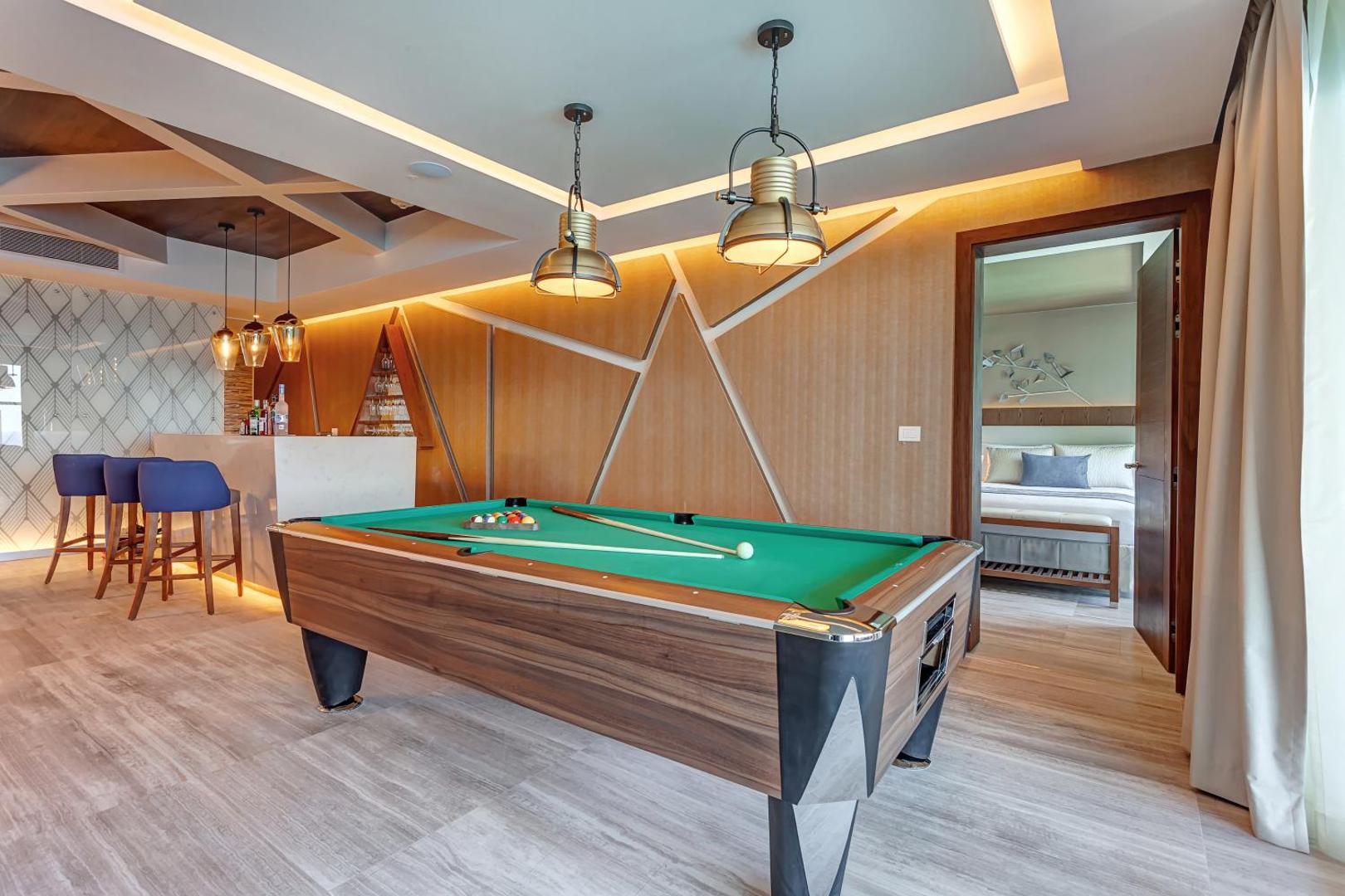 Royalton CHIC Cancun atpūtas zona ar biljarda galdu, bāru un ieeju guļamistabā luksusa apartamentos Kankunā.