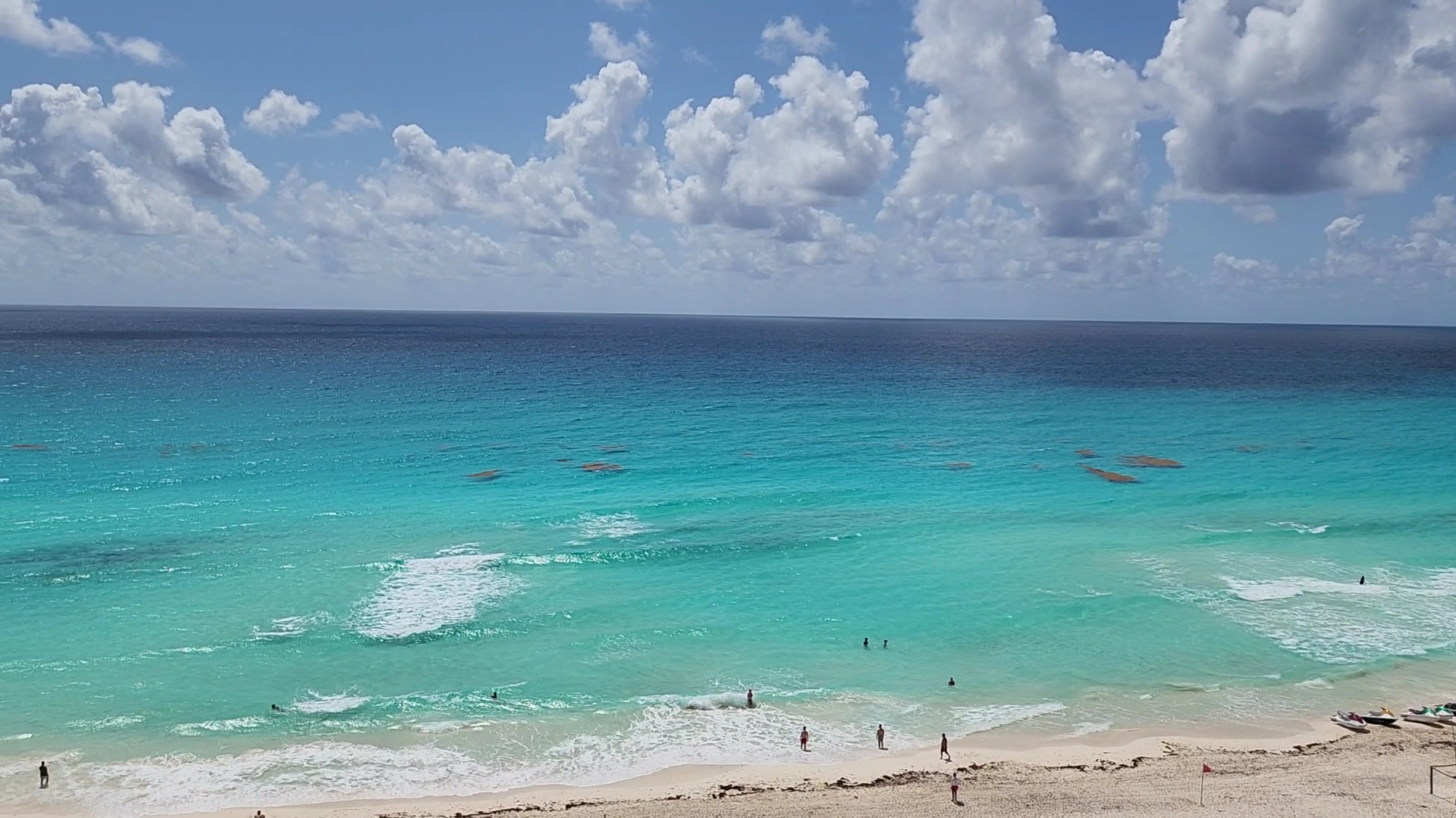 Royalton CHIC Cancun kūrorta skats uz tirkīzzilo Karību jūru un balto smilšu pludmali Kankunā, Meksikā ar atpūtniekiem krastā