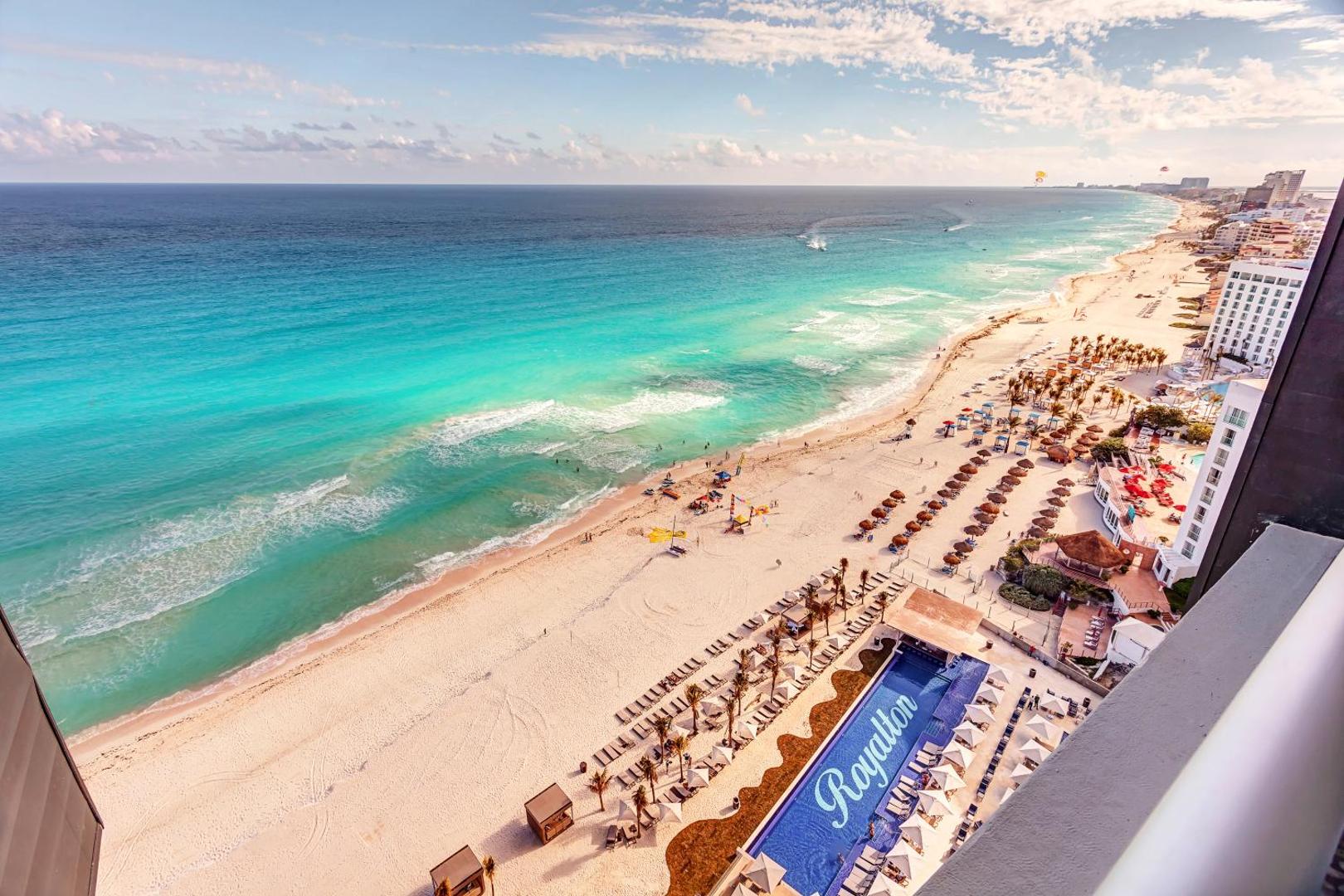 Skats no augšas uz Royalton CHIC Cancun privāto pludmali, tirkīza krāsas Karību jūru un viesnīcas baseinu