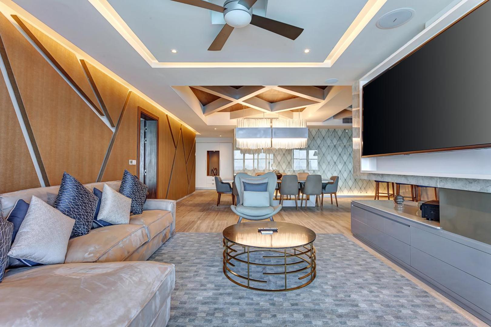 Royalton CHIC Cancun luksusa numura viesistaba ar modernu dīvānu, lielu TV ekrānu un elegantu ēdamzonu Kankunā, Meksikā