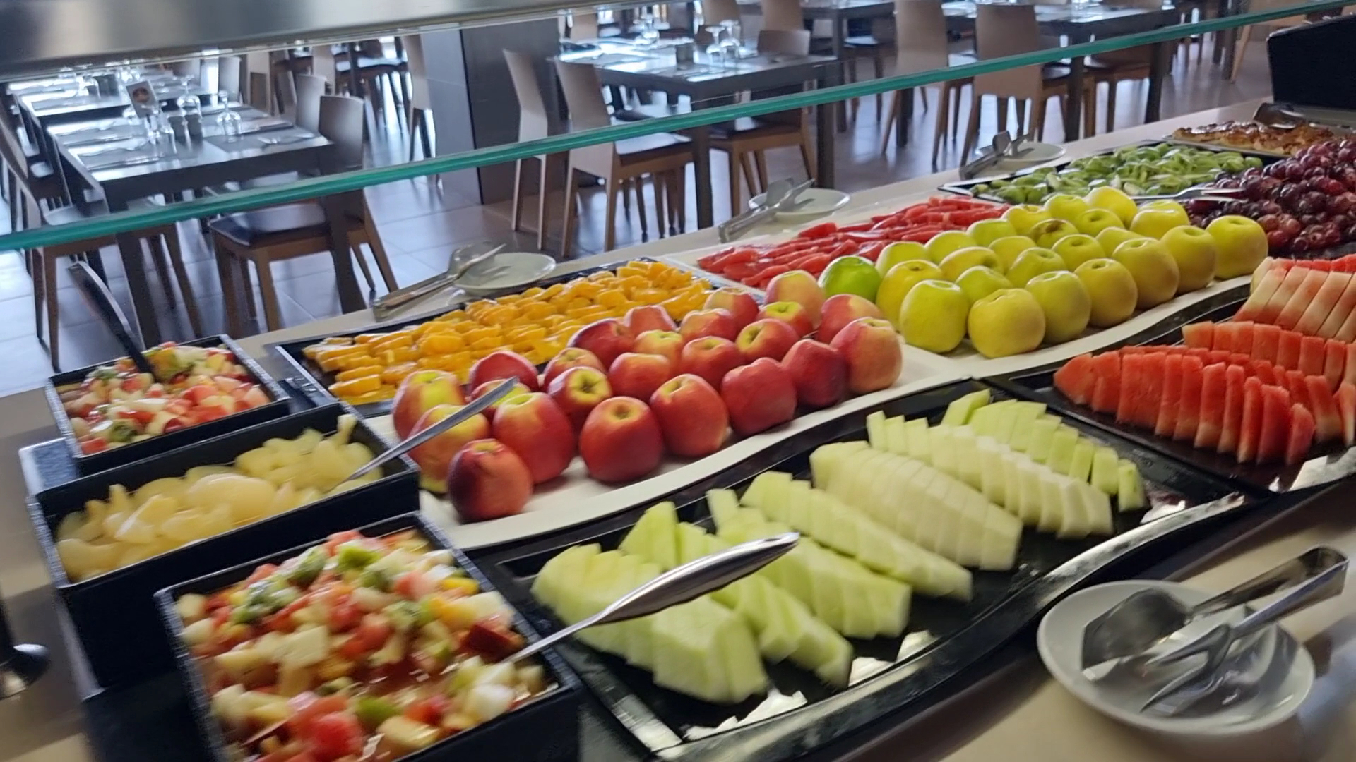 RIU Vistamar restorāna bufetes zona ar plašu svaigu augļu izvēli, tostarp melonēm, āboliem un vīnogām viesu brokastīm