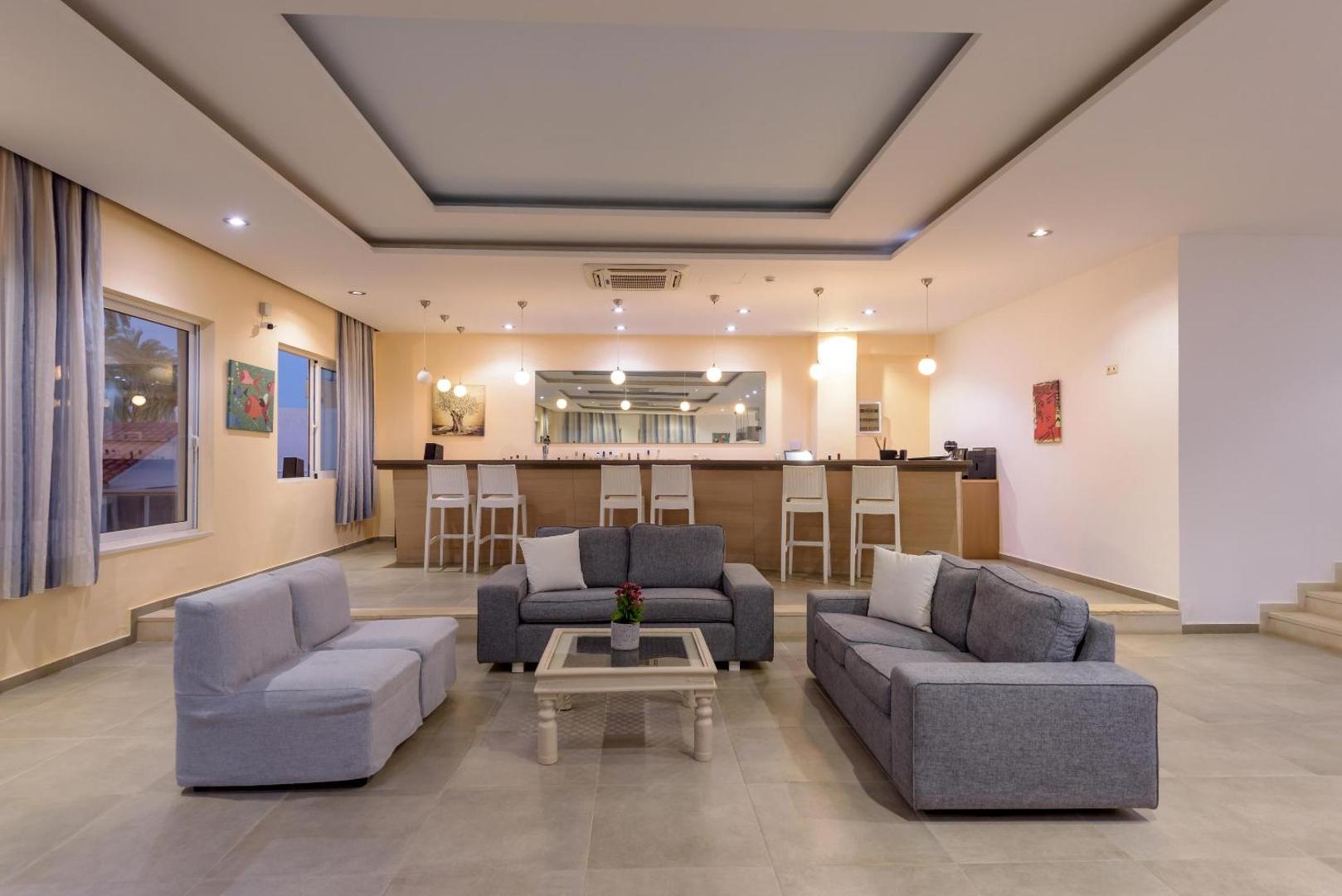 Zeus Palm Beach Hotel vestibila bārs ar moderniem dīvāniem, atpūtas zonu un bāra leti ar augstajiem krēsliem