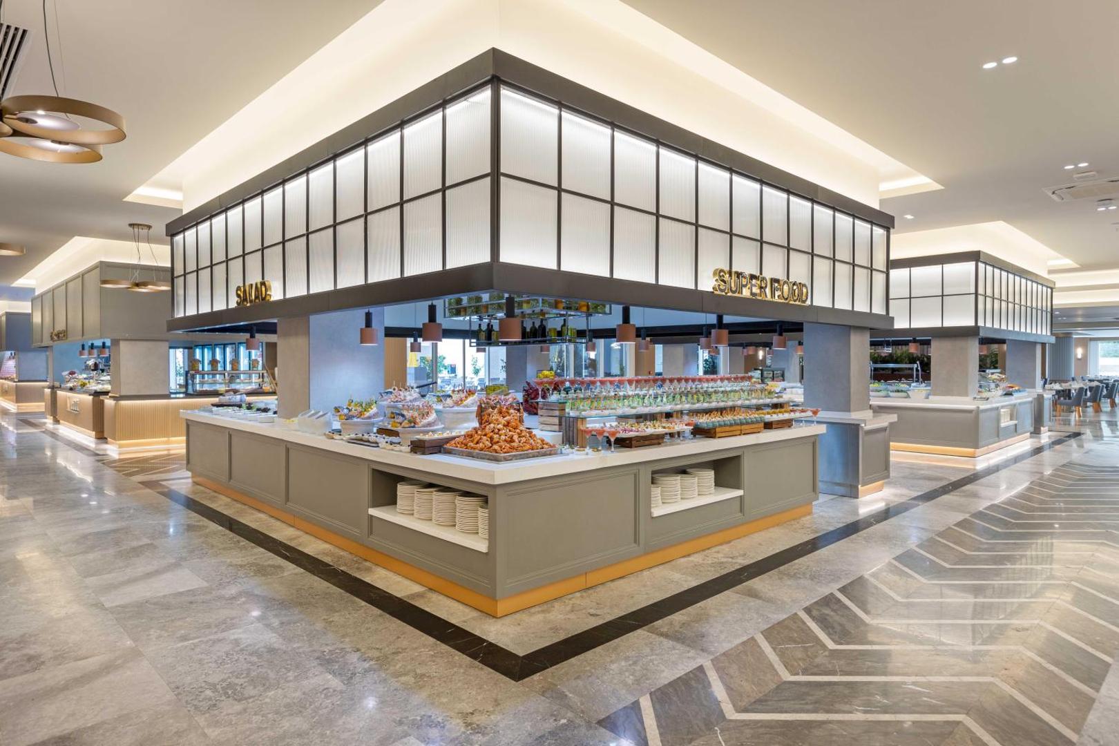 Kirman Hotels Belazur Resort & Spa galvenā restorāna bufetes zona ar plašu salātu un veselīgā uztura stendu izvēli Belekā.