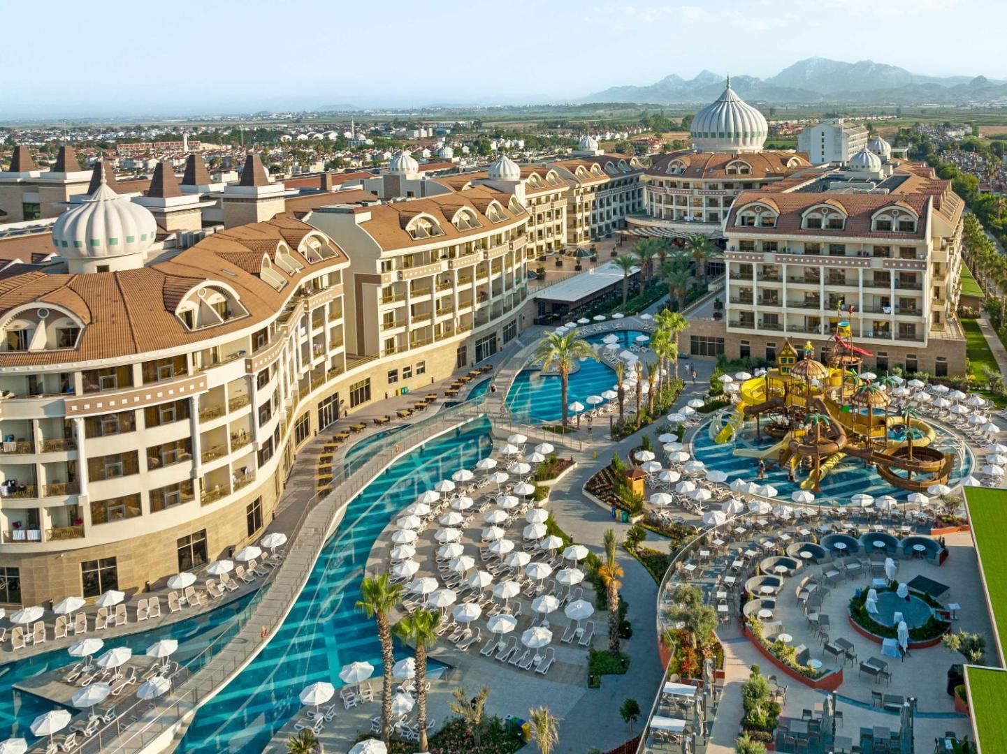 Kirman Hotels Belazur Resort & Spa kopskats no augšas uz baseiniem, bērnu ūdens atrakciju parku un viesnīcas korpusiem Belekā