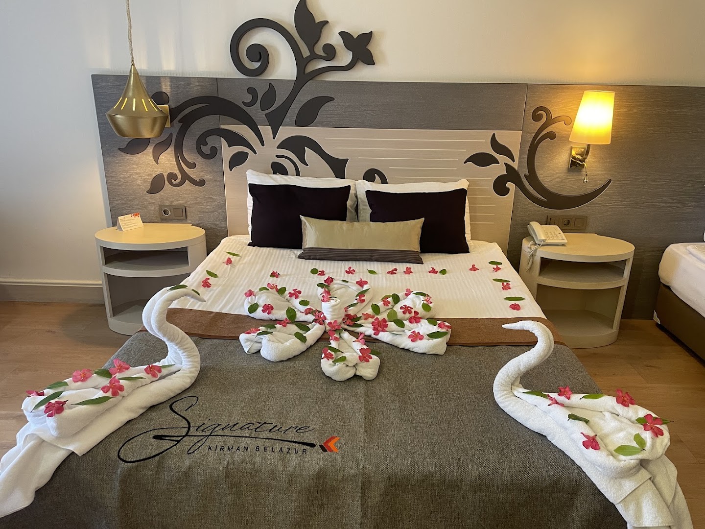 Kirman Belazur Resort & Spa viesnīcas numurs ar dekorētu gultu, dvieļu gulbjiem un ziediem īpašam sagaidīšanas brīdim